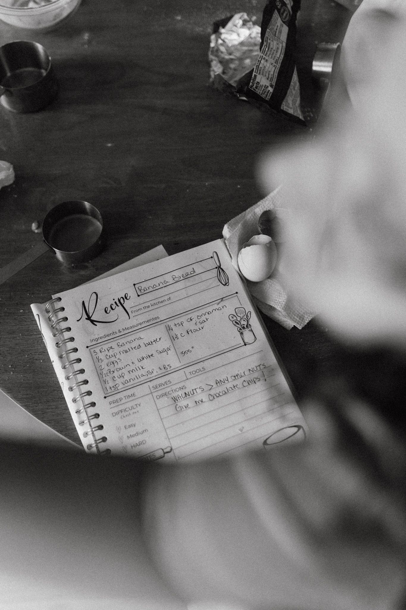 Handwritten notes in a spiral notebook photographed in black and white.