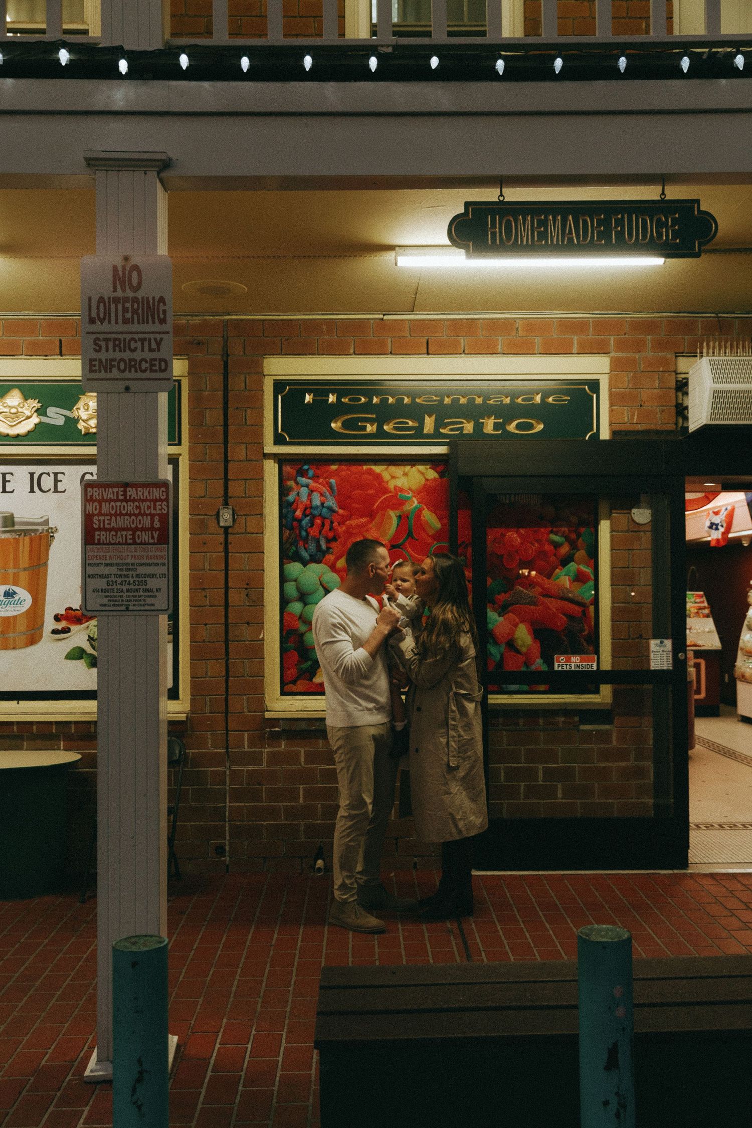 People waiting in line at a homemade fudge counter in a brick-walled retail shop.