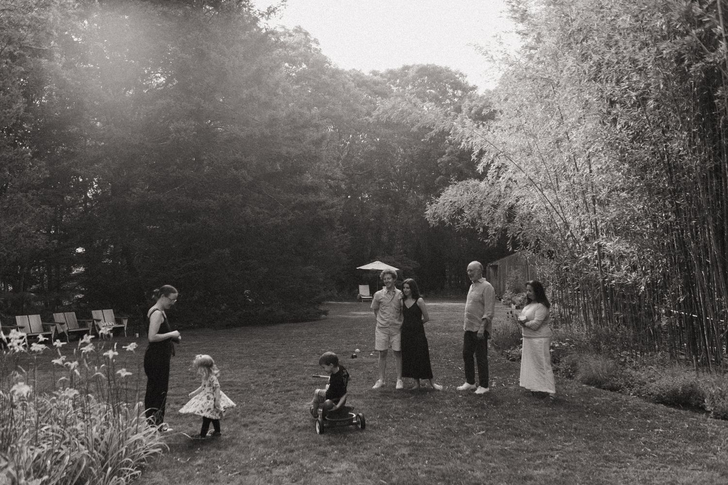 Vintage black and white photo of families gathering in a garden setting.