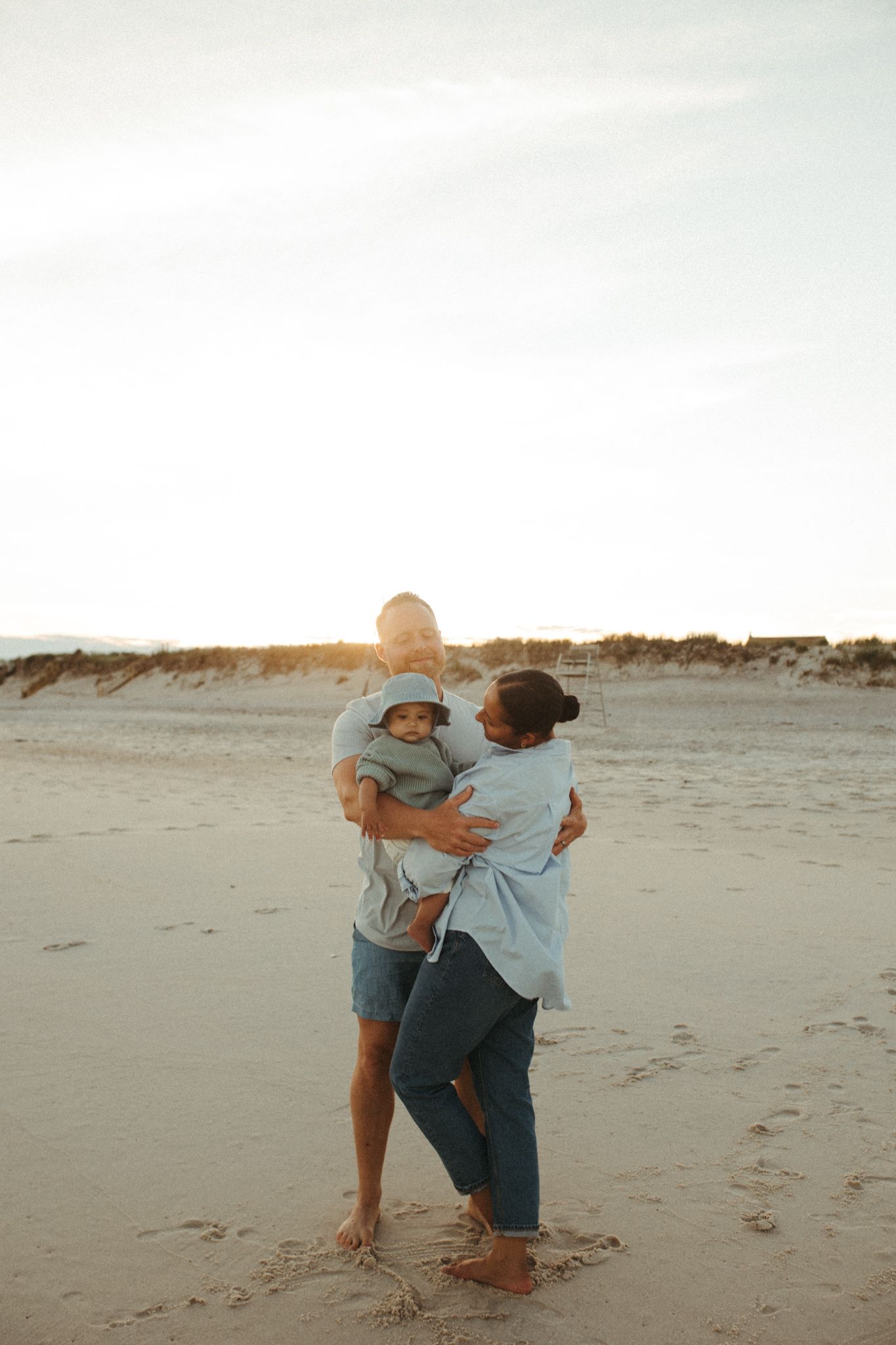 Playful interactions between two people on a sandy beach at sunset.