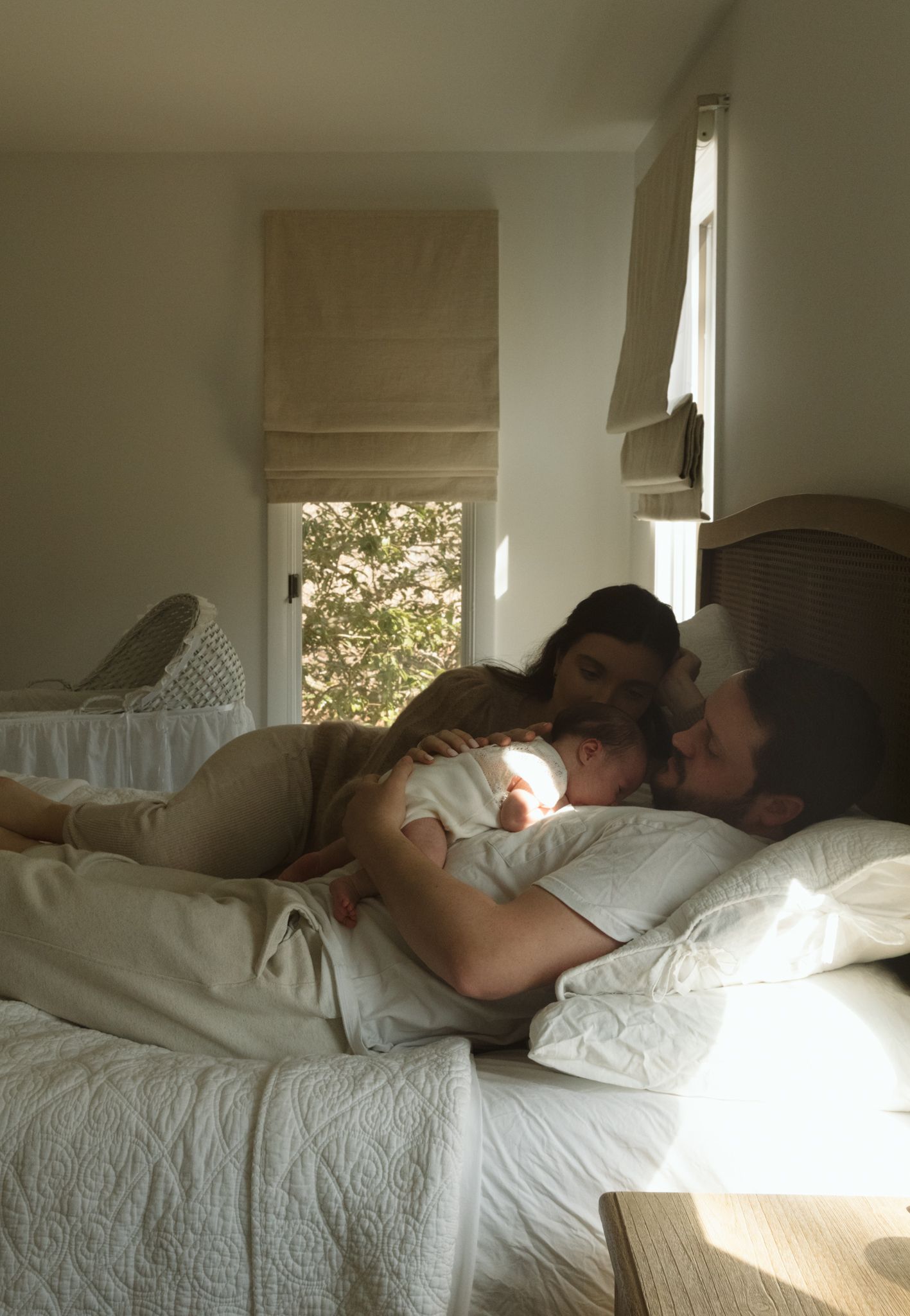 Sunlit bedroom scene with white bedding and natural window light.
