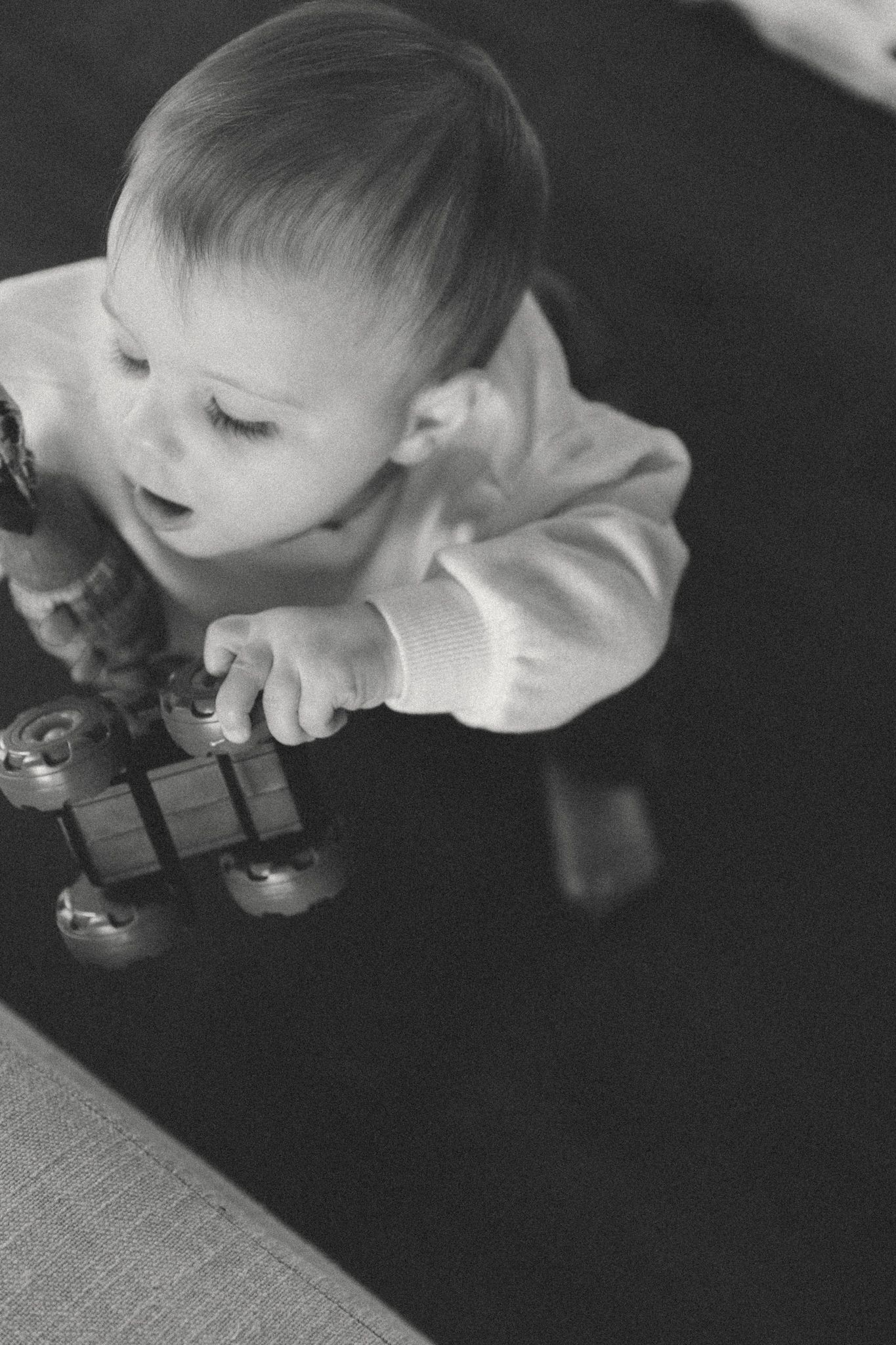 Black and white close-up photos showing interaction with toys in dramatic lighting.