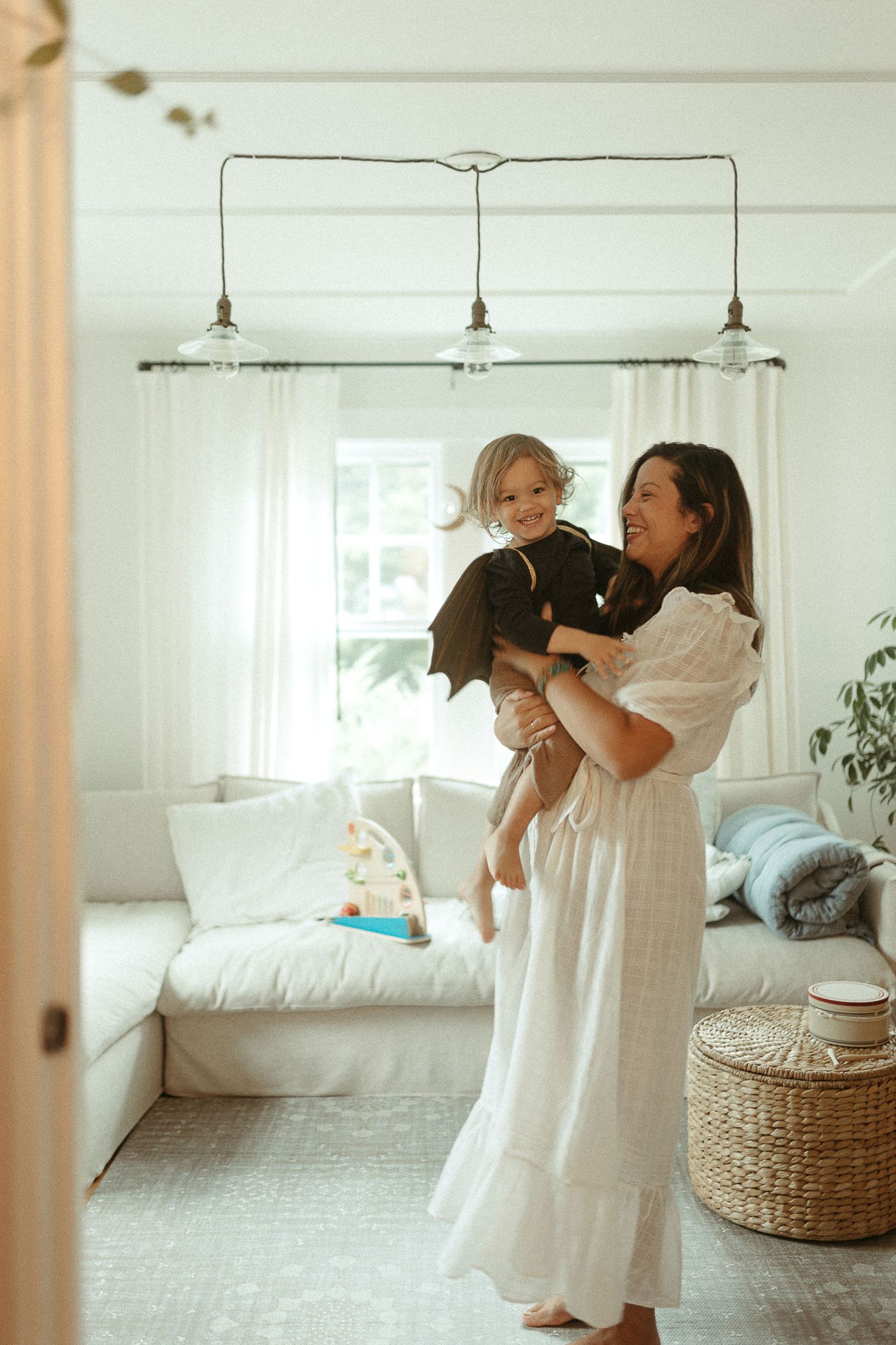 Series of joyful dance movements captured in a bright white room with natural lighting.