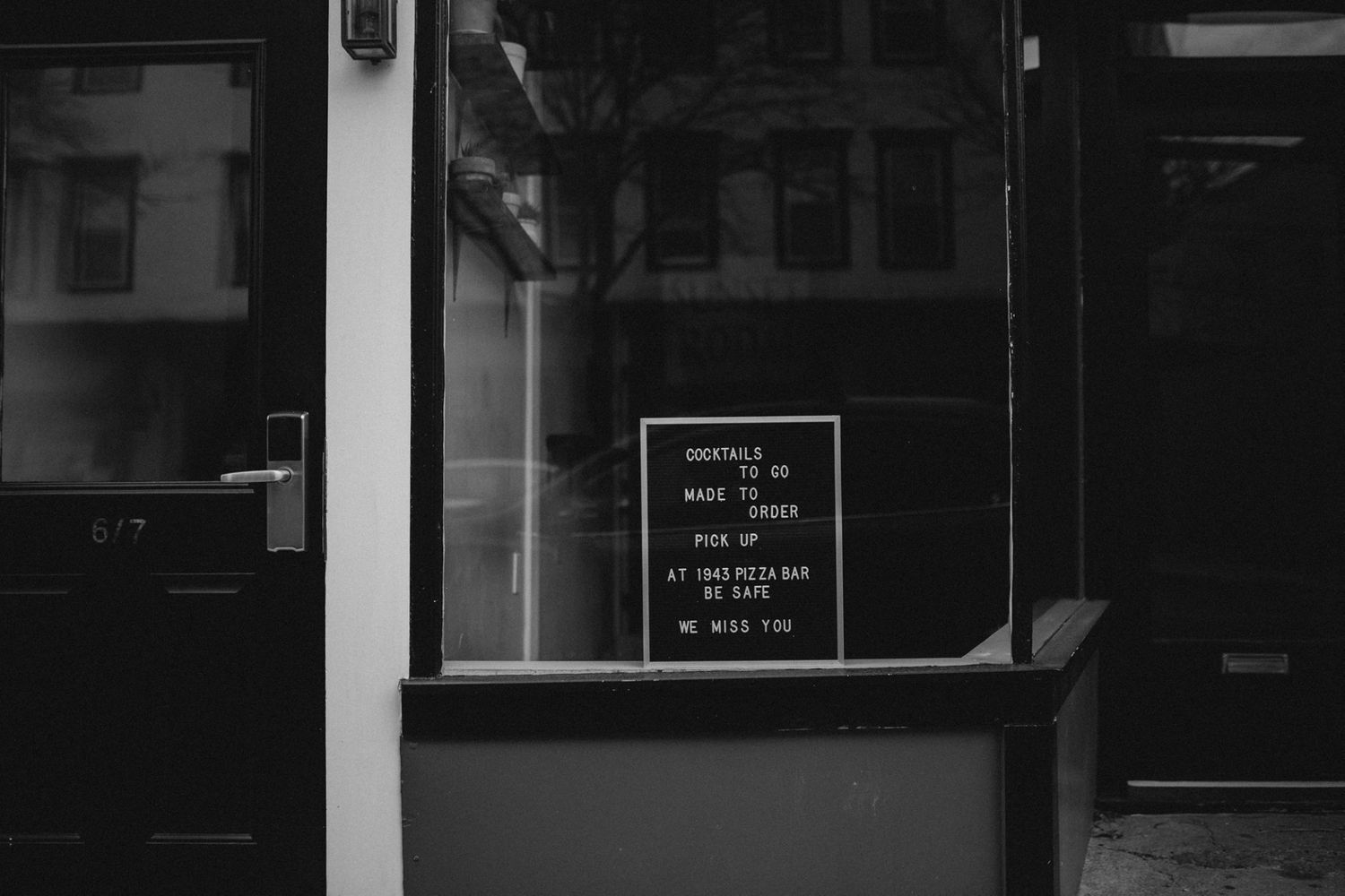 Dark storefront windows reflecting light in a moody black and white composition.