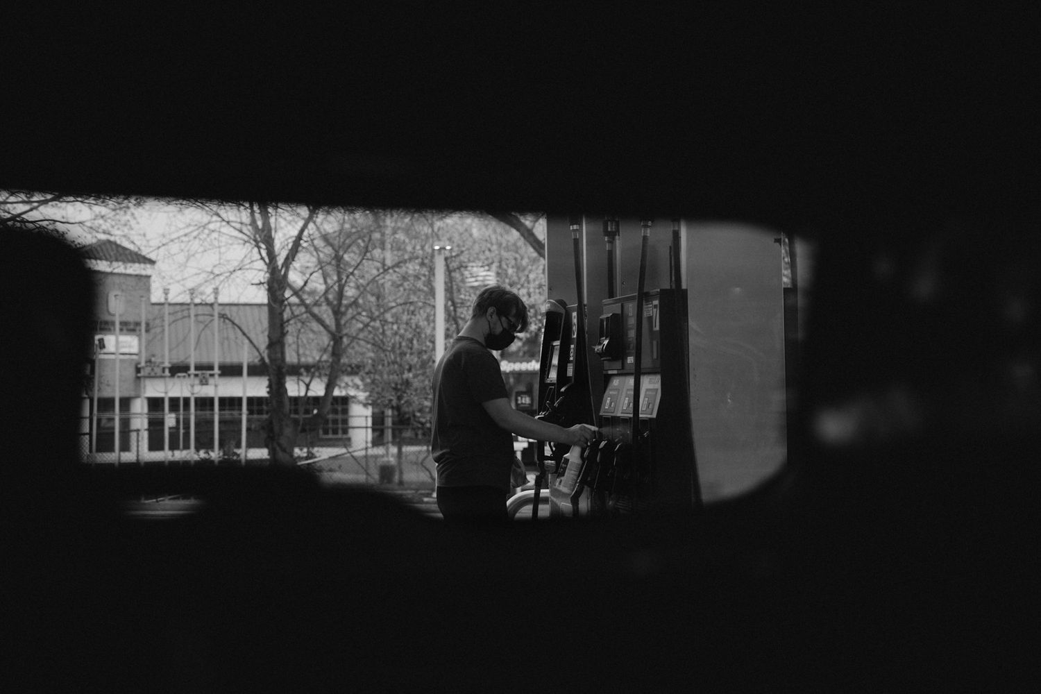 A silhouetted figure viewed through a window in black and white.