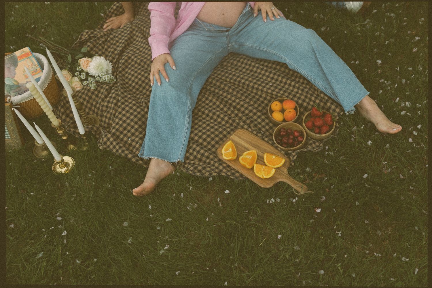 Overhead view of a picnic setup with food and drinks on a plaid blanket.