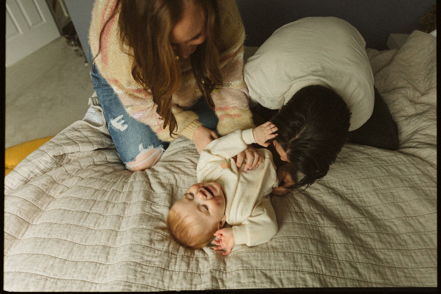 A tender family moment shared on a quilted bedspread.