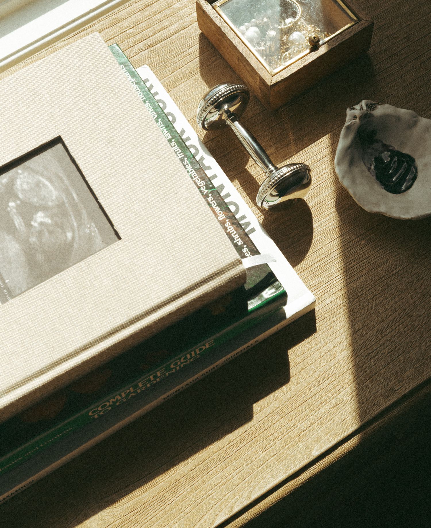 Sunlit wooden desk surface with scattered items creating dramatic shadows.