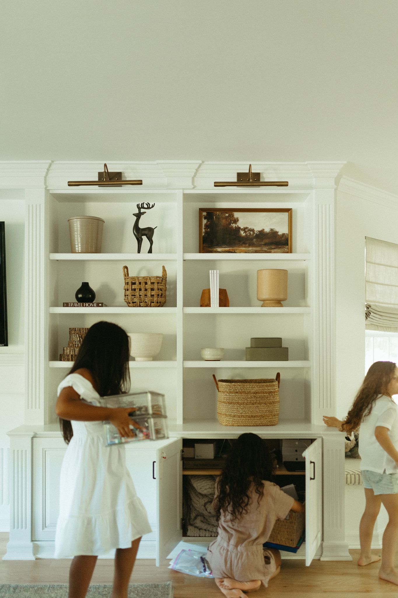 Sequence showing movement around white built-in shelves and furniture in a bright room.