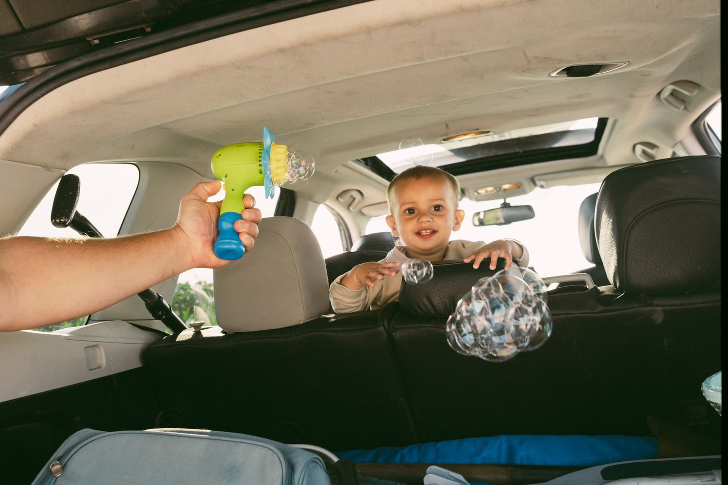 Playful moment inside a car with toys and laughter.