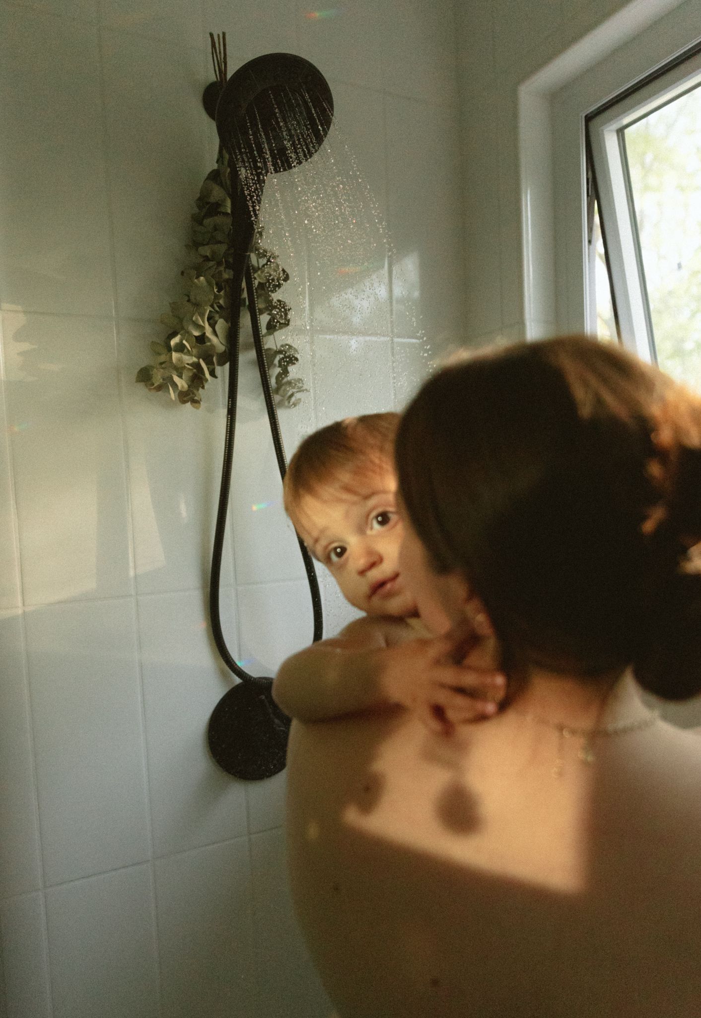 Artistic bathroom scene with plants and dramatic lighting.