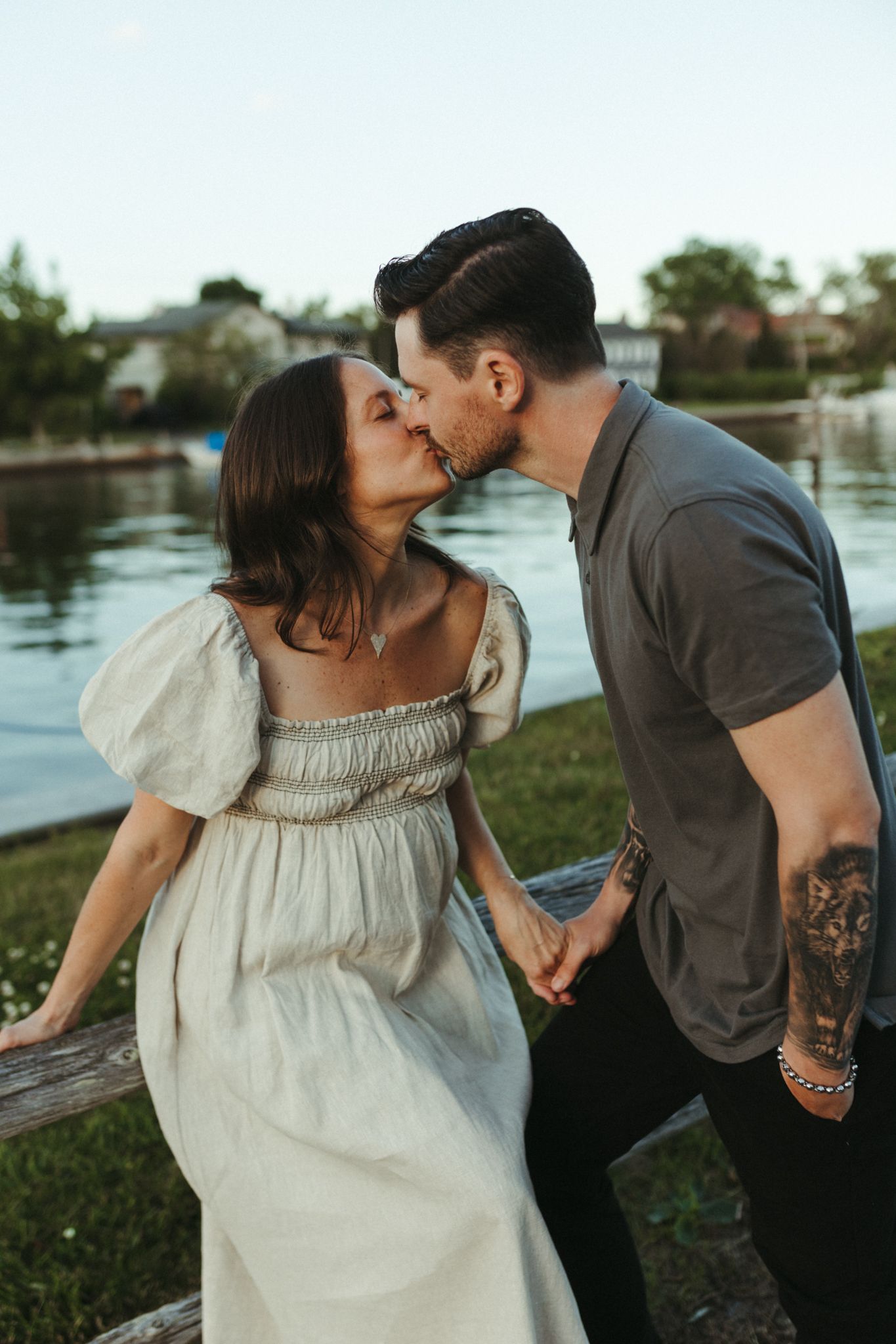 Romantic moments shared between a couple by the waterfront at sunset.