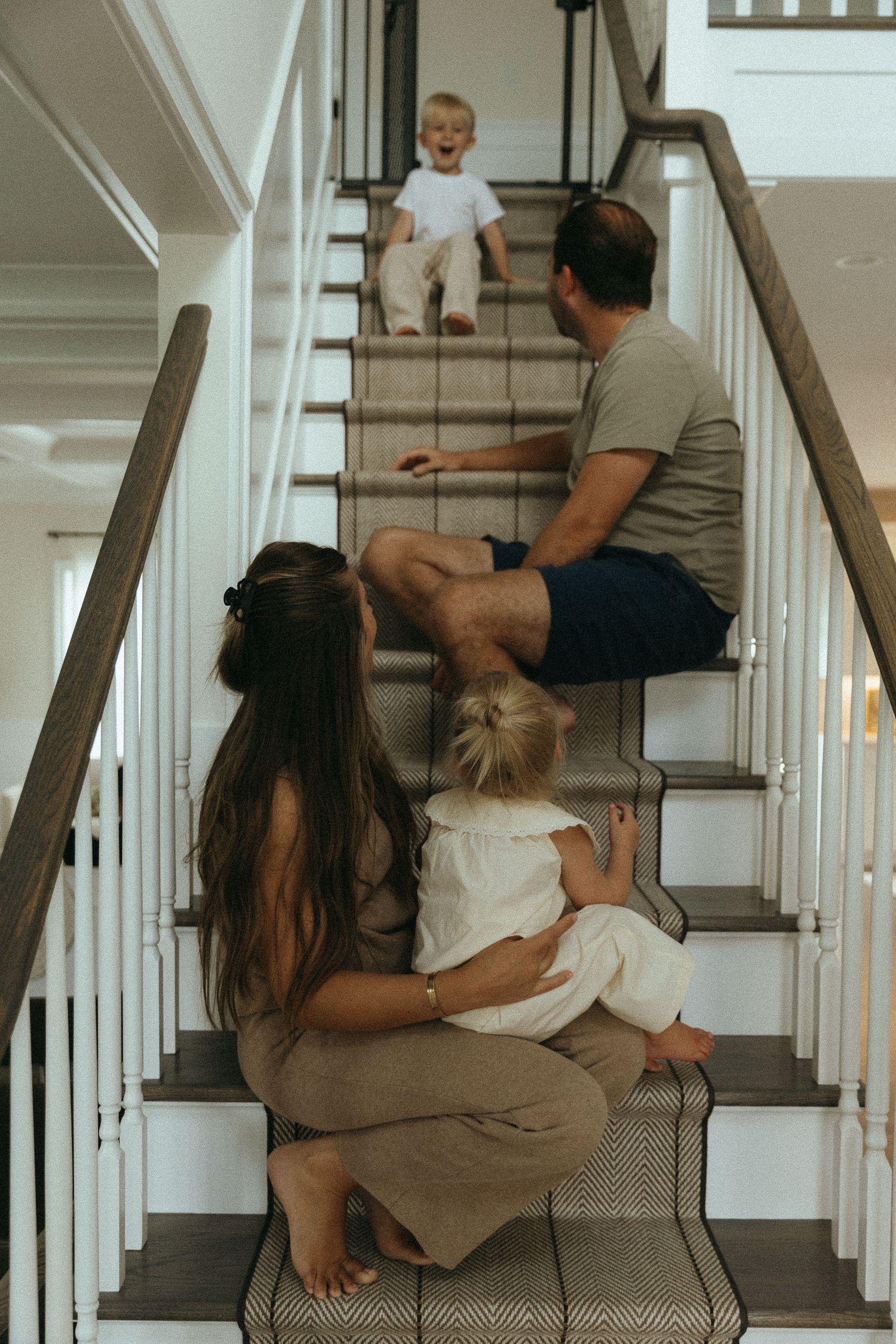 Candid moments captured on indoor staircase in warm lighting.