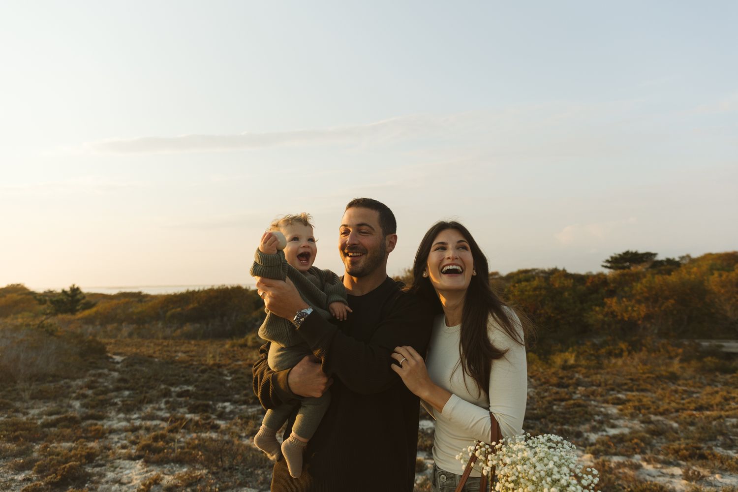 A happy family sharing a tender moment outdoors during golden hour.