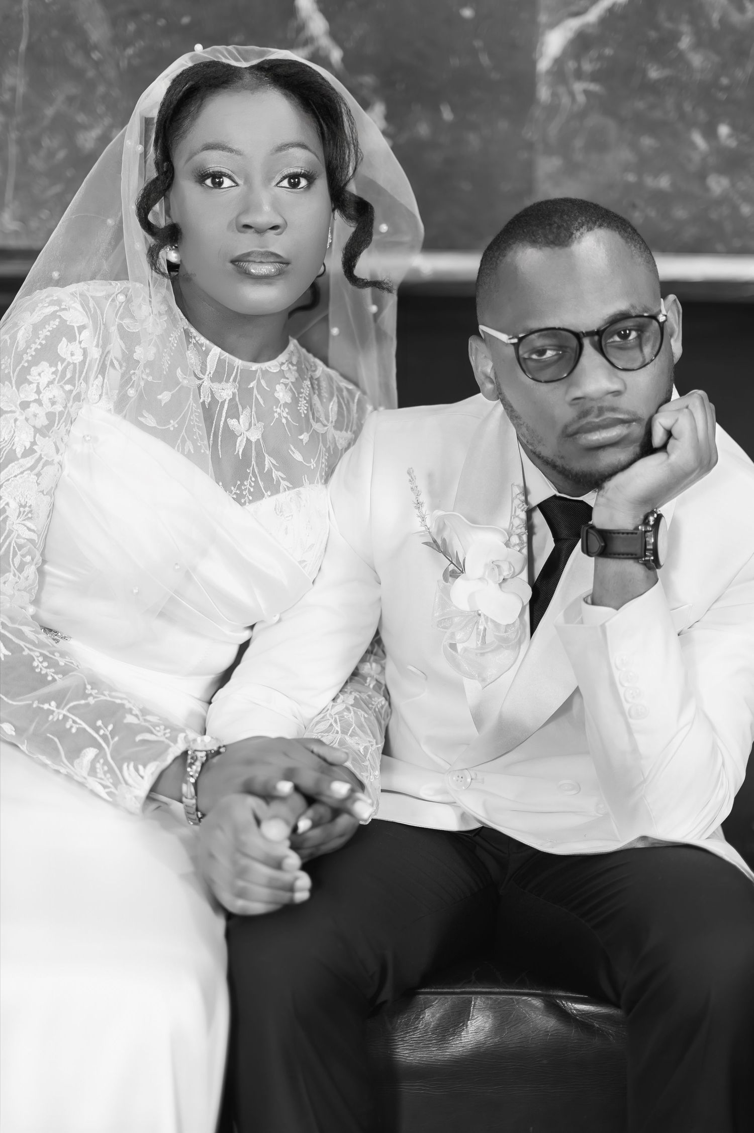 Elegant black and white wedding portrait of African American bride and groom holding hands.