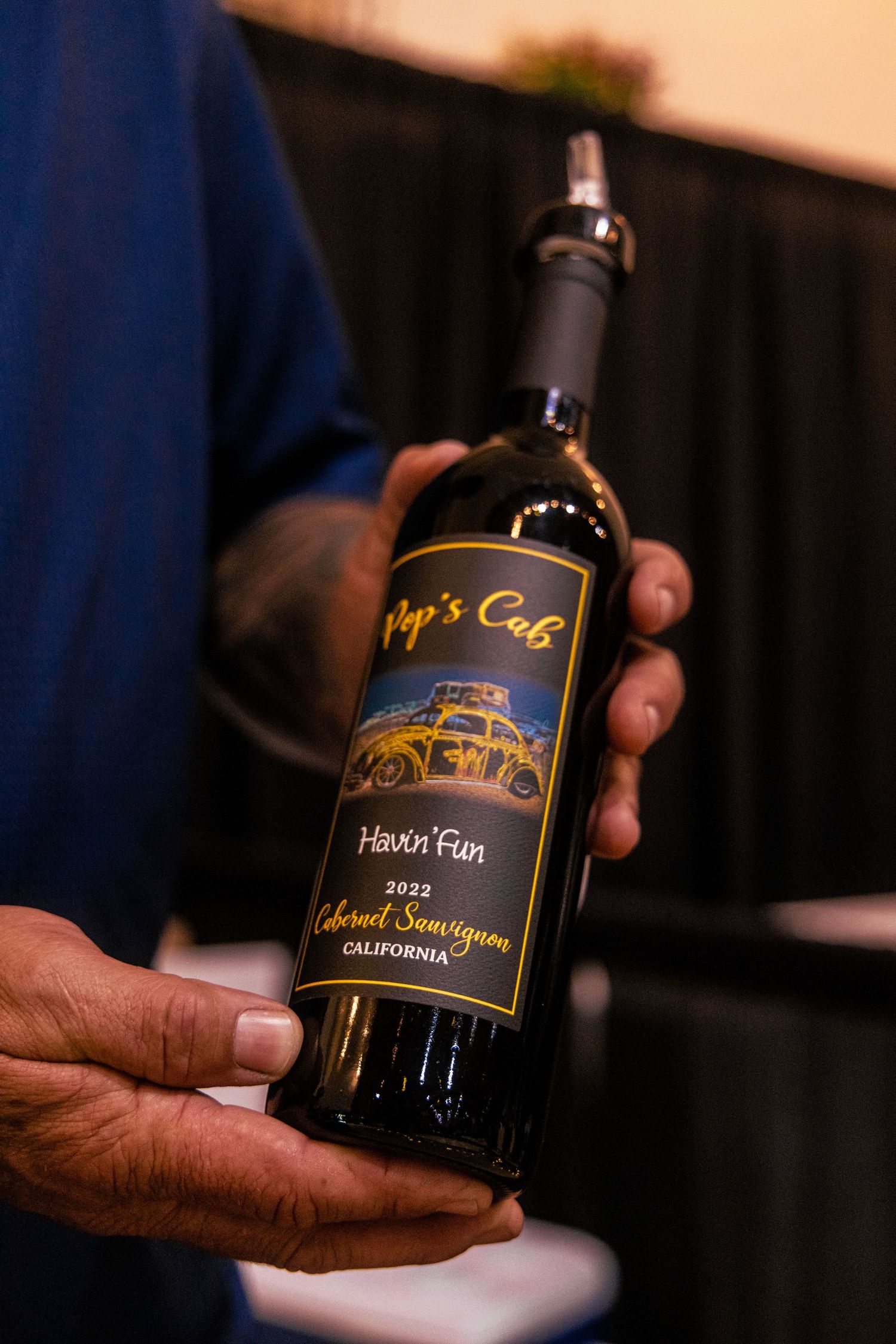 Hand holding a bottle of Pops Cab Havin Fun 2022 Cabernet Sauvignon California wine.
