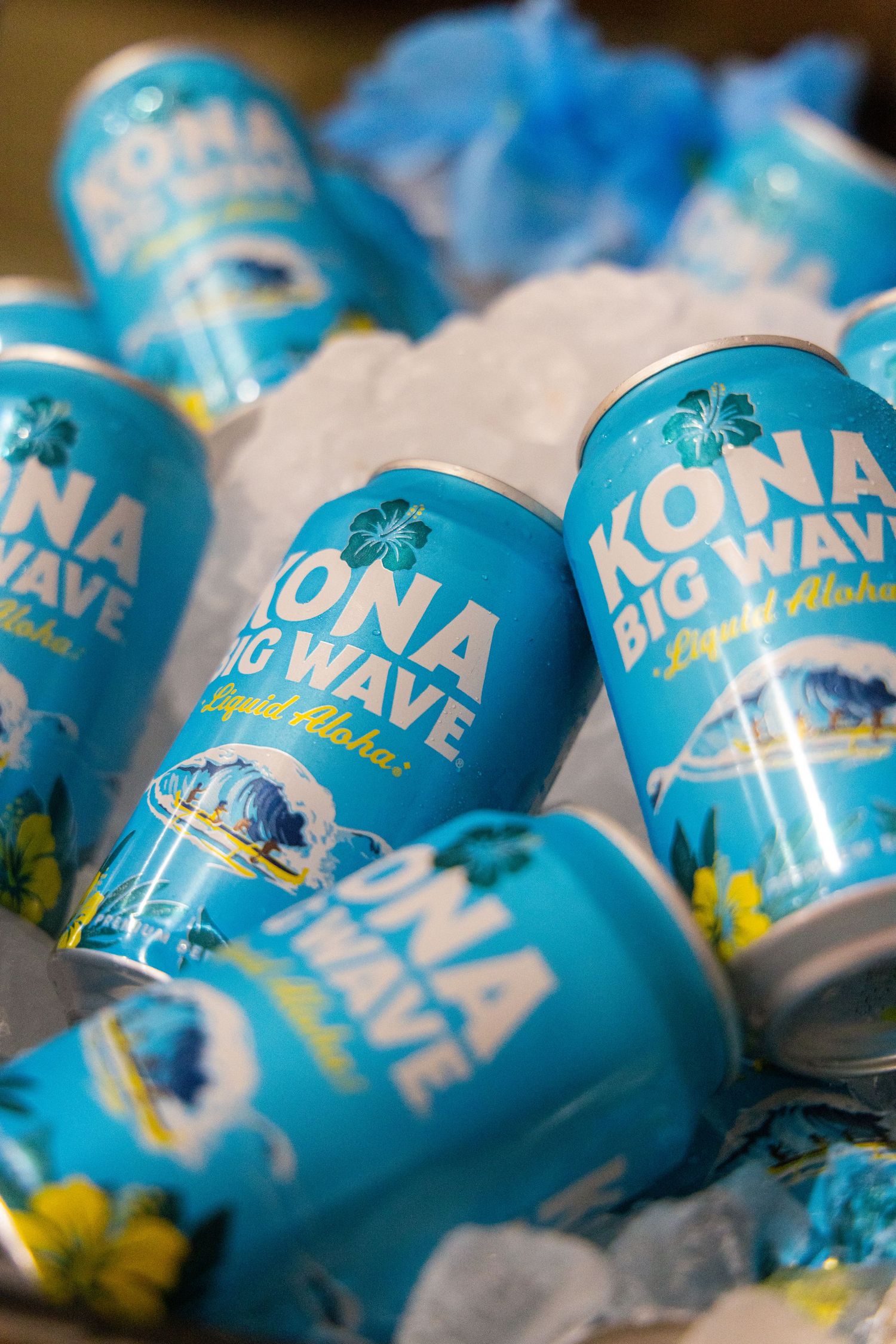 Kona Big Wave Liquid Aloha beer cans chilled on ice at a tropical themed party.
