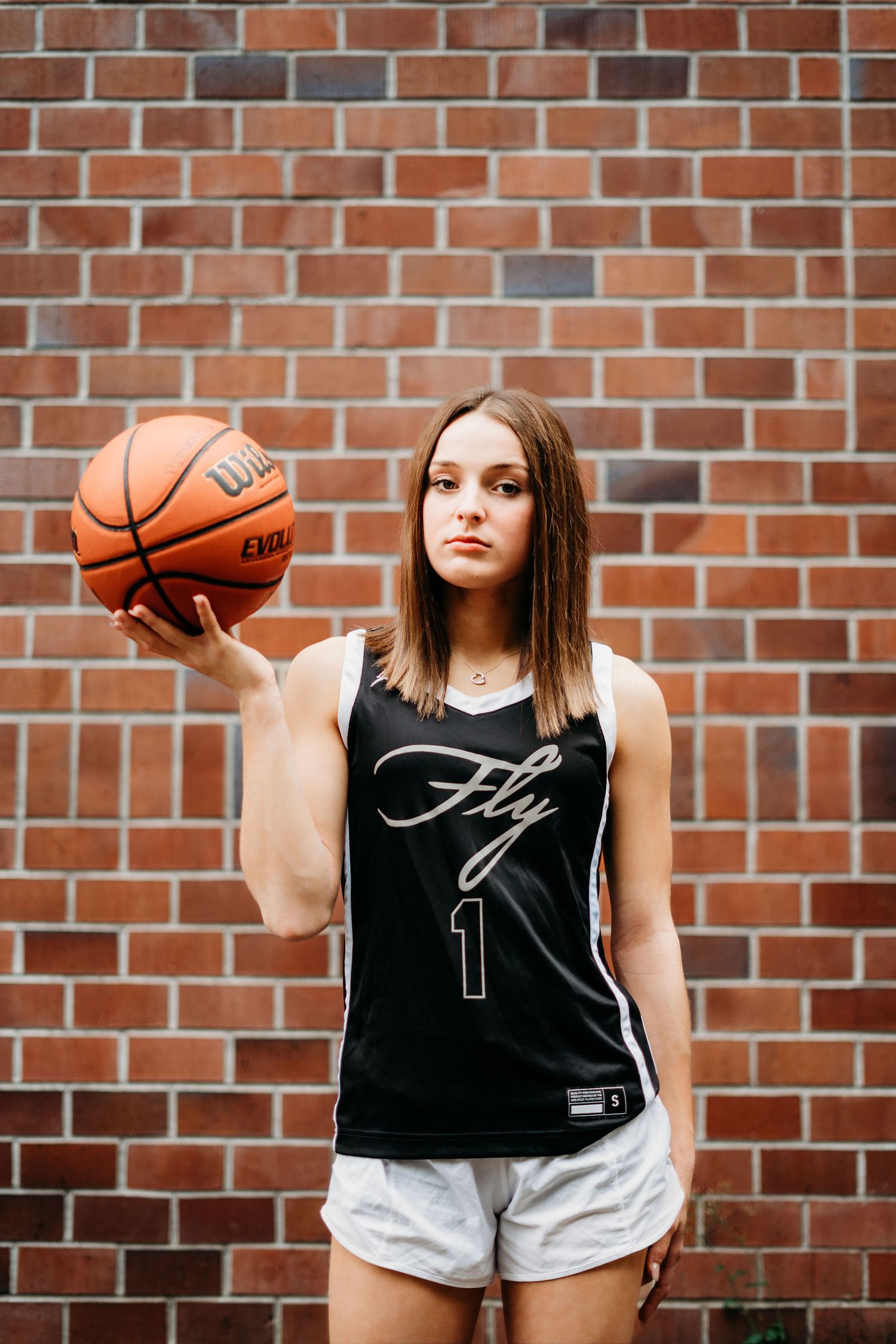 Sassy senior girl holding a basketball.
