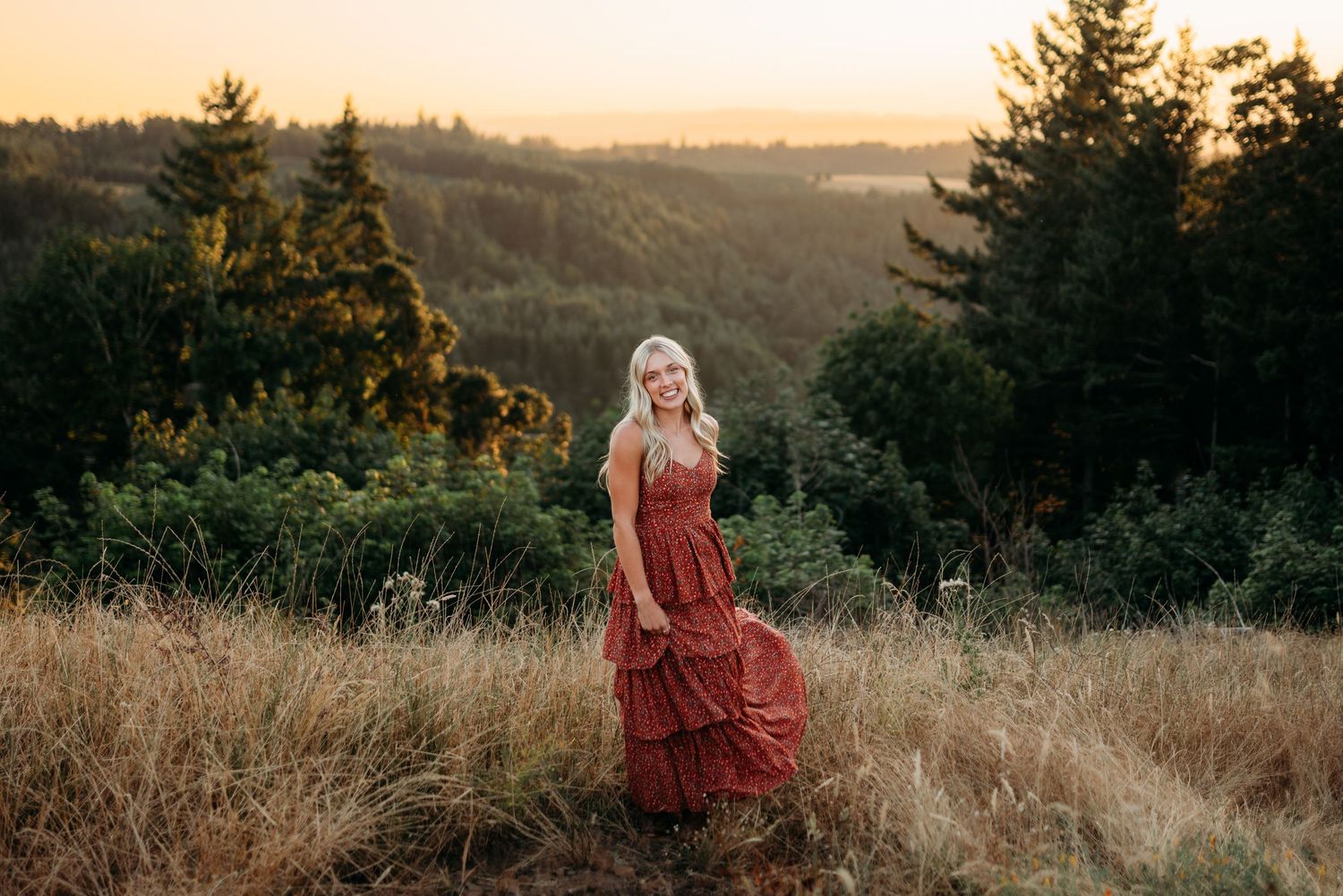 Senior girl standing with flowing dress at sunset
