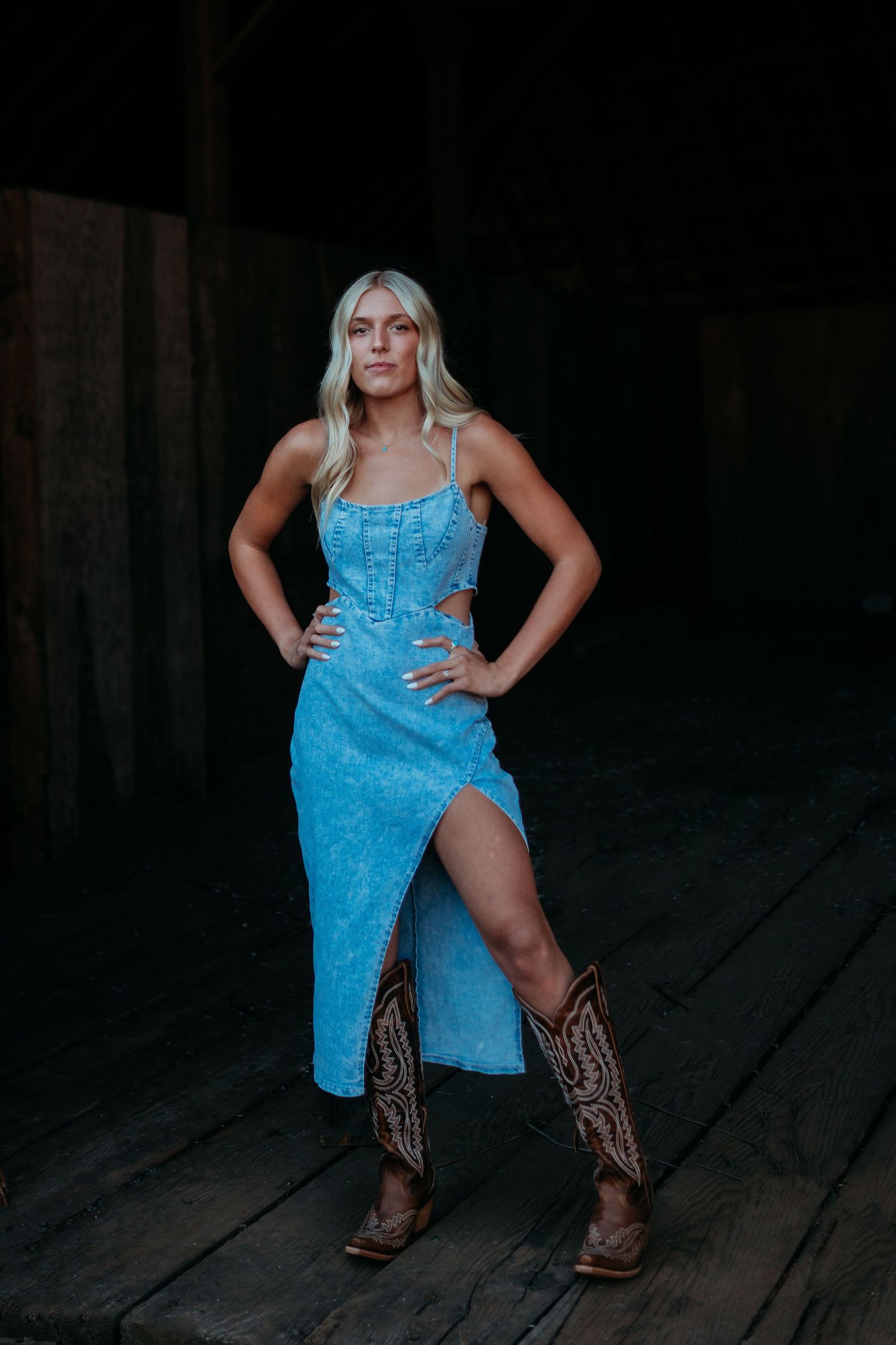 Senior girl standing confidently in a blue dress during an indoor portrait