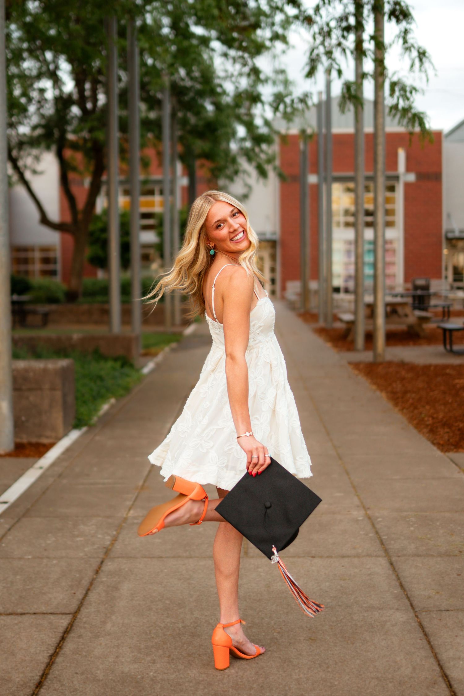 Silverton Oregon graduation photo of a girl in orange heels flipping her hair.