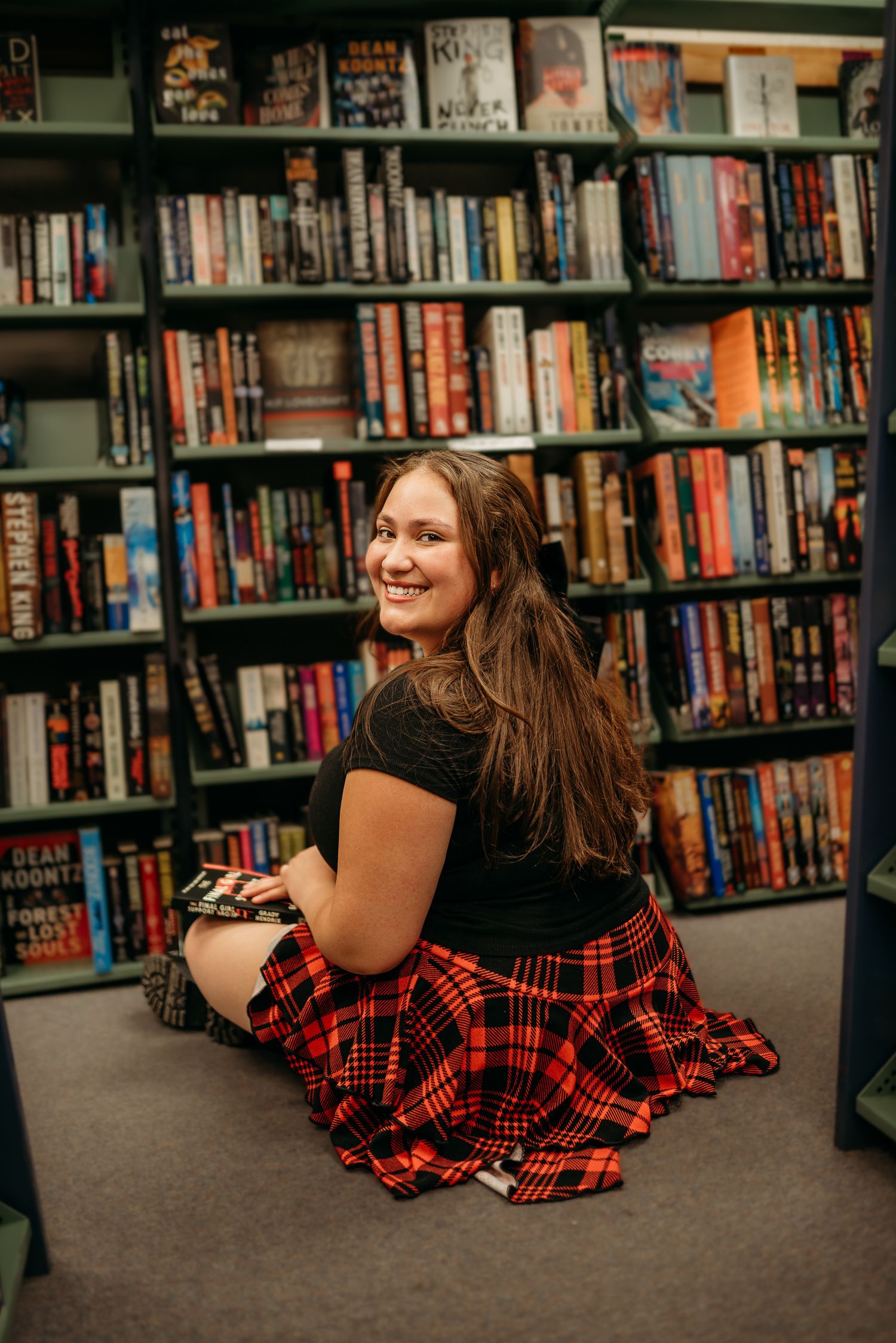 Senior girl sitting in book store naturally smiling