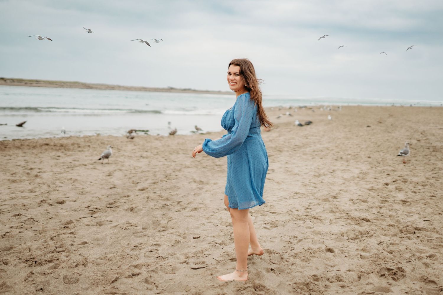 Senior girl walking along the beach during an outdoor session at the Oregon Coast.