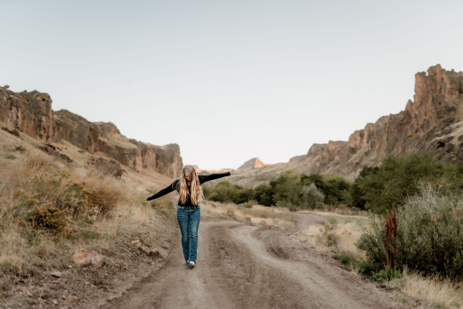Senior girl walking on a dirt road in eastern Oregon