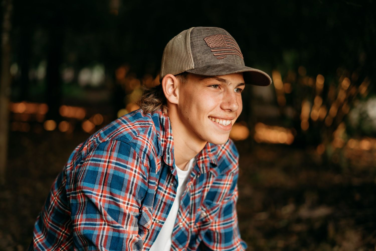 Senior boy wearing a hat, smiling during an outdoor portrait