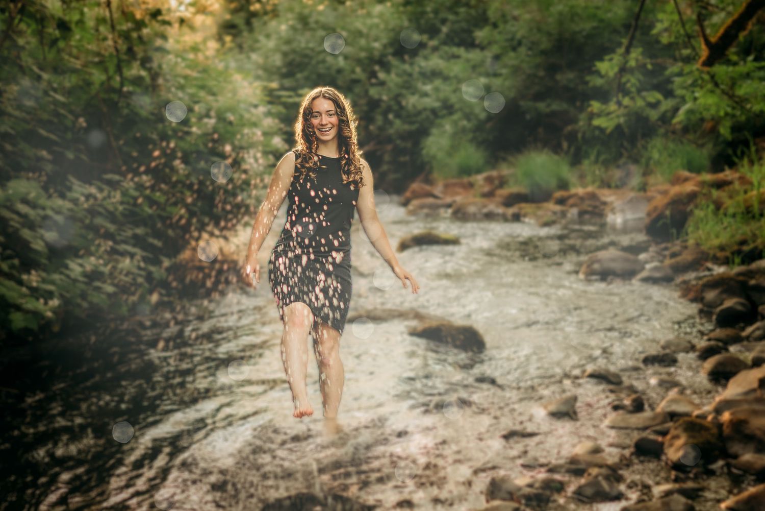 Senior girl walking through a rocky creek during an outdoor session