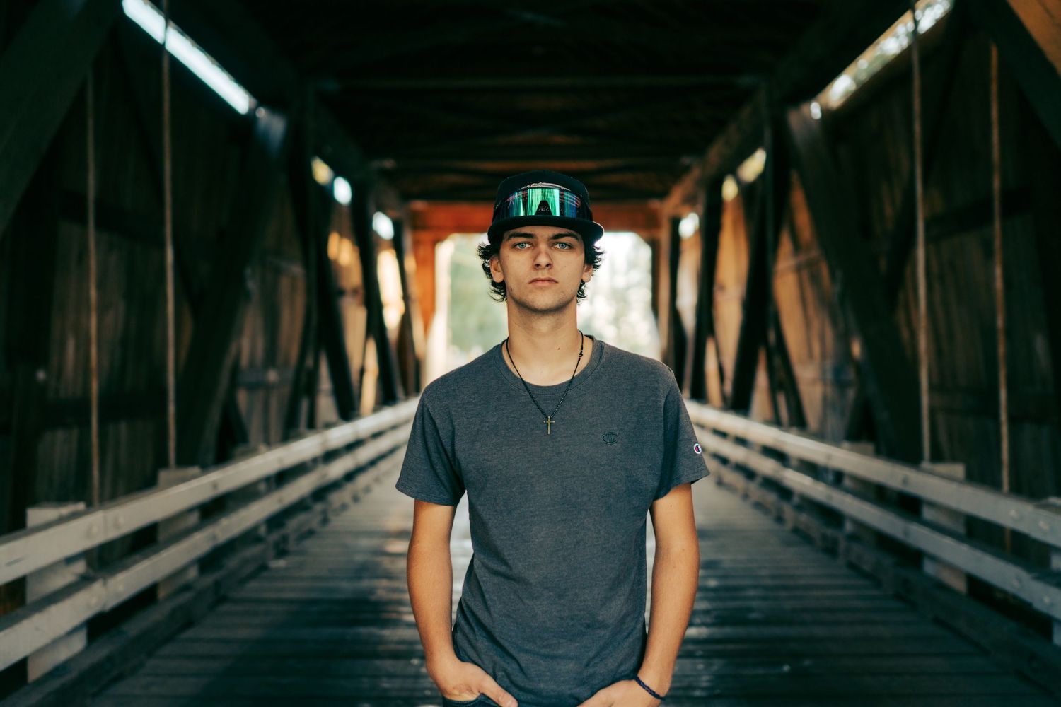 Senior boy standing on a bridge in an urban portrait setting