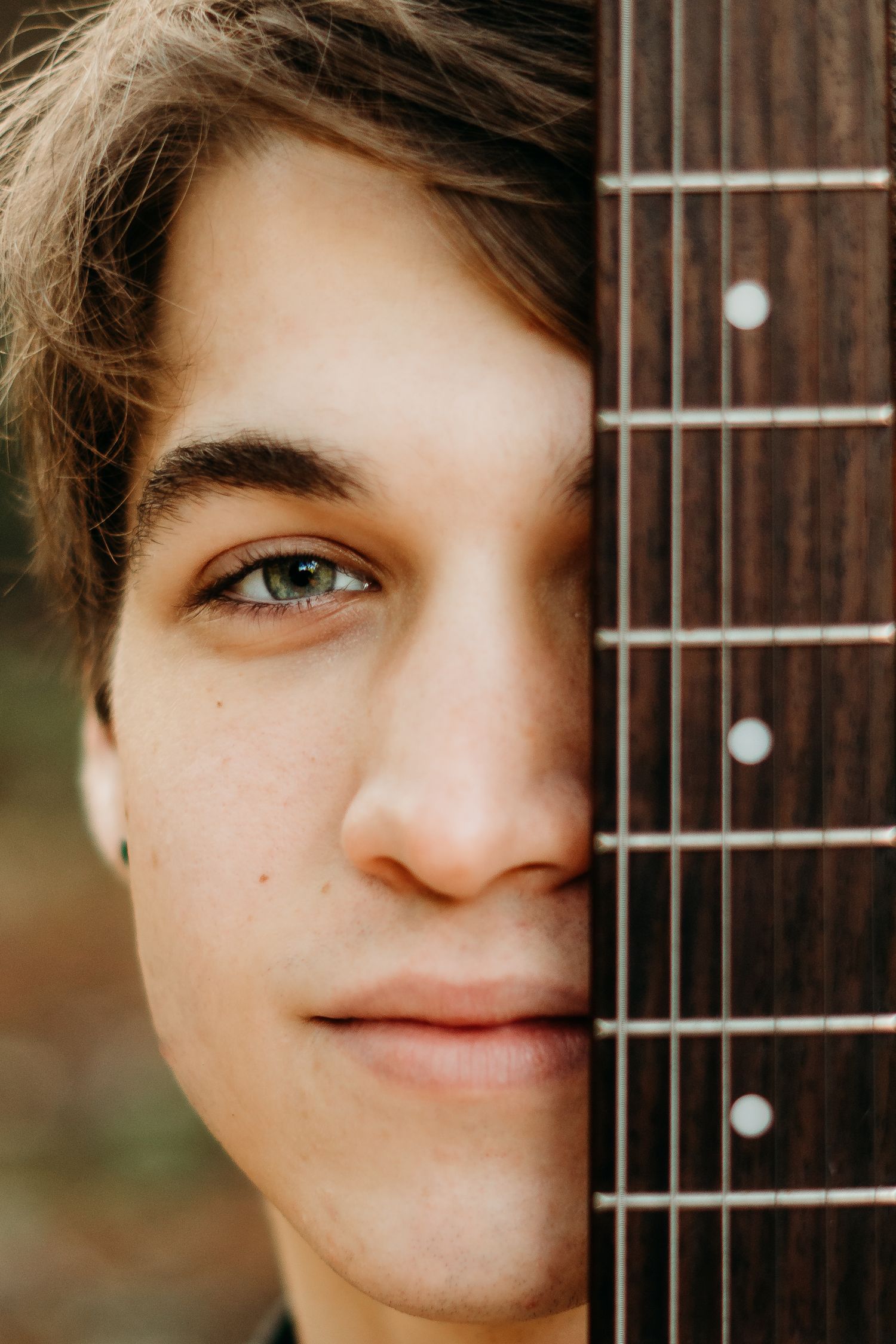 Close-up portrait of a senior boy holding his guitar