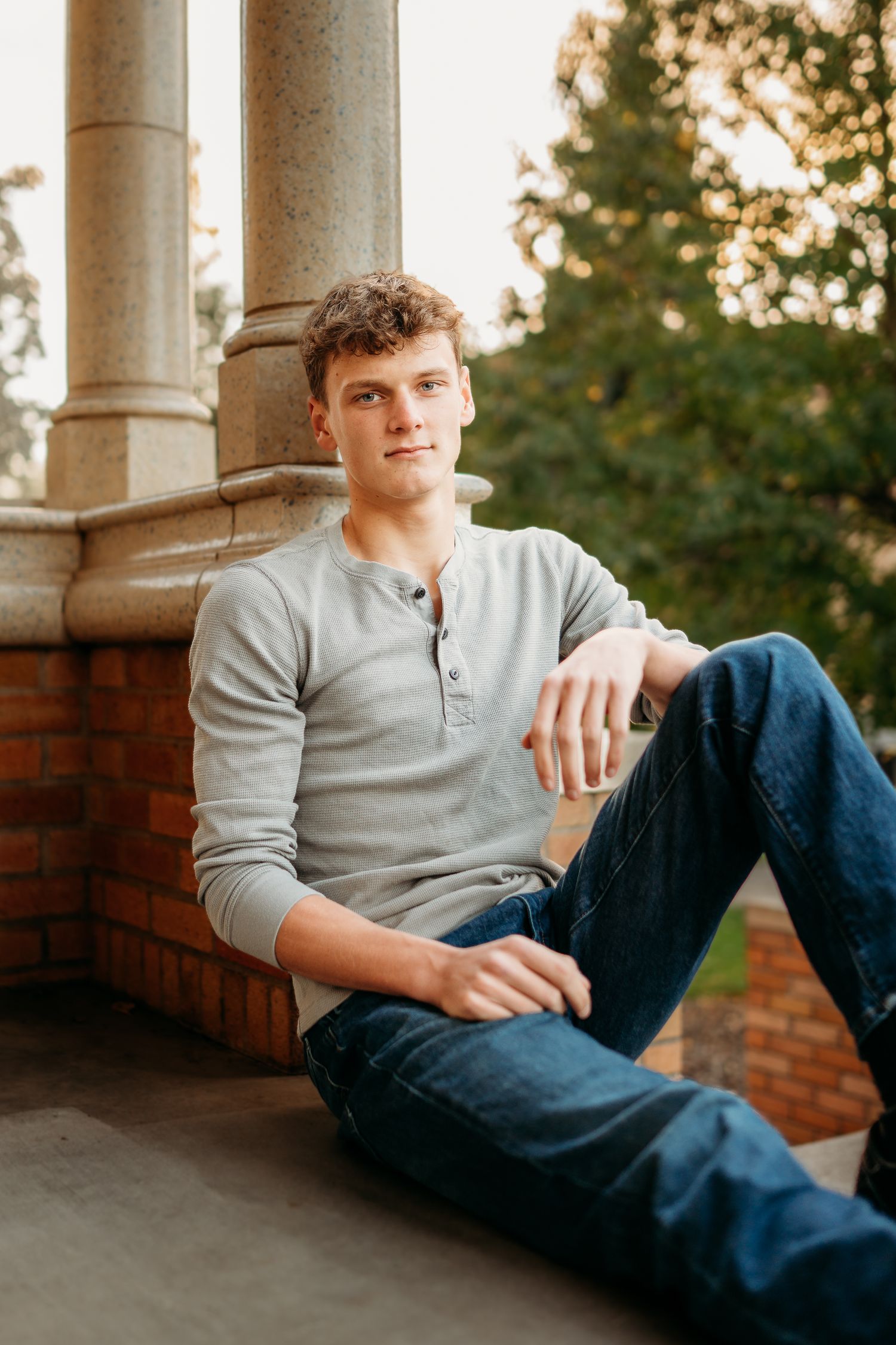 Senior boy sitting on steps with relaxed, confident posture