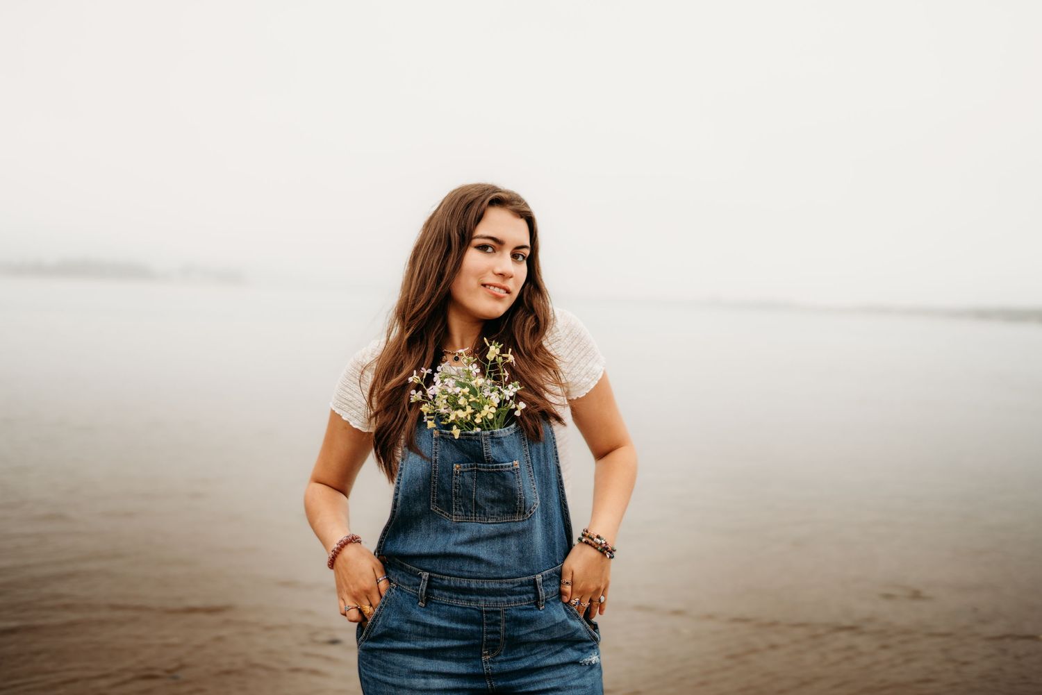 Senior girls with flowers in pocket standing confidently at the Oregon Coast.
