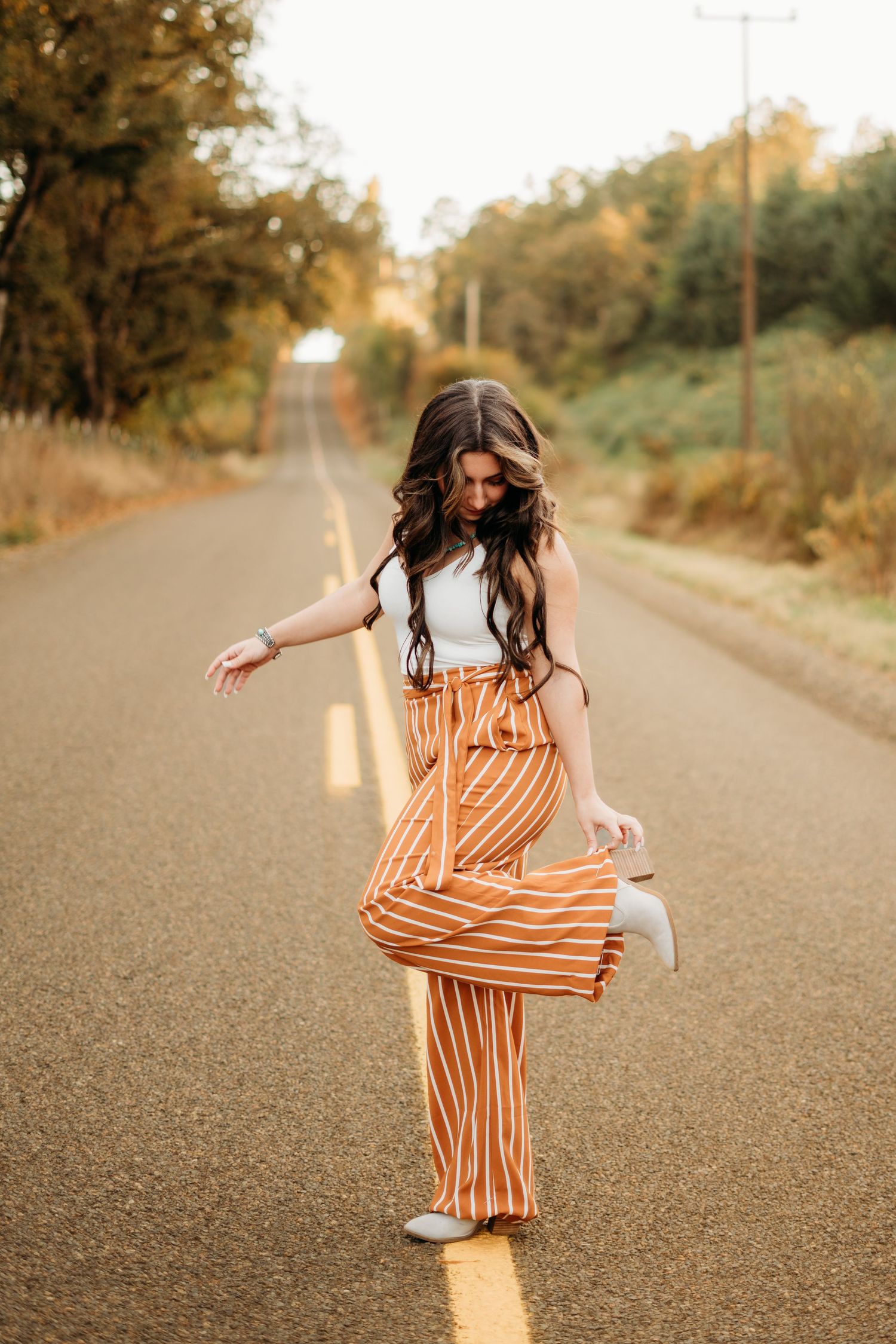 Senior girls standing in road and fixing her shoe