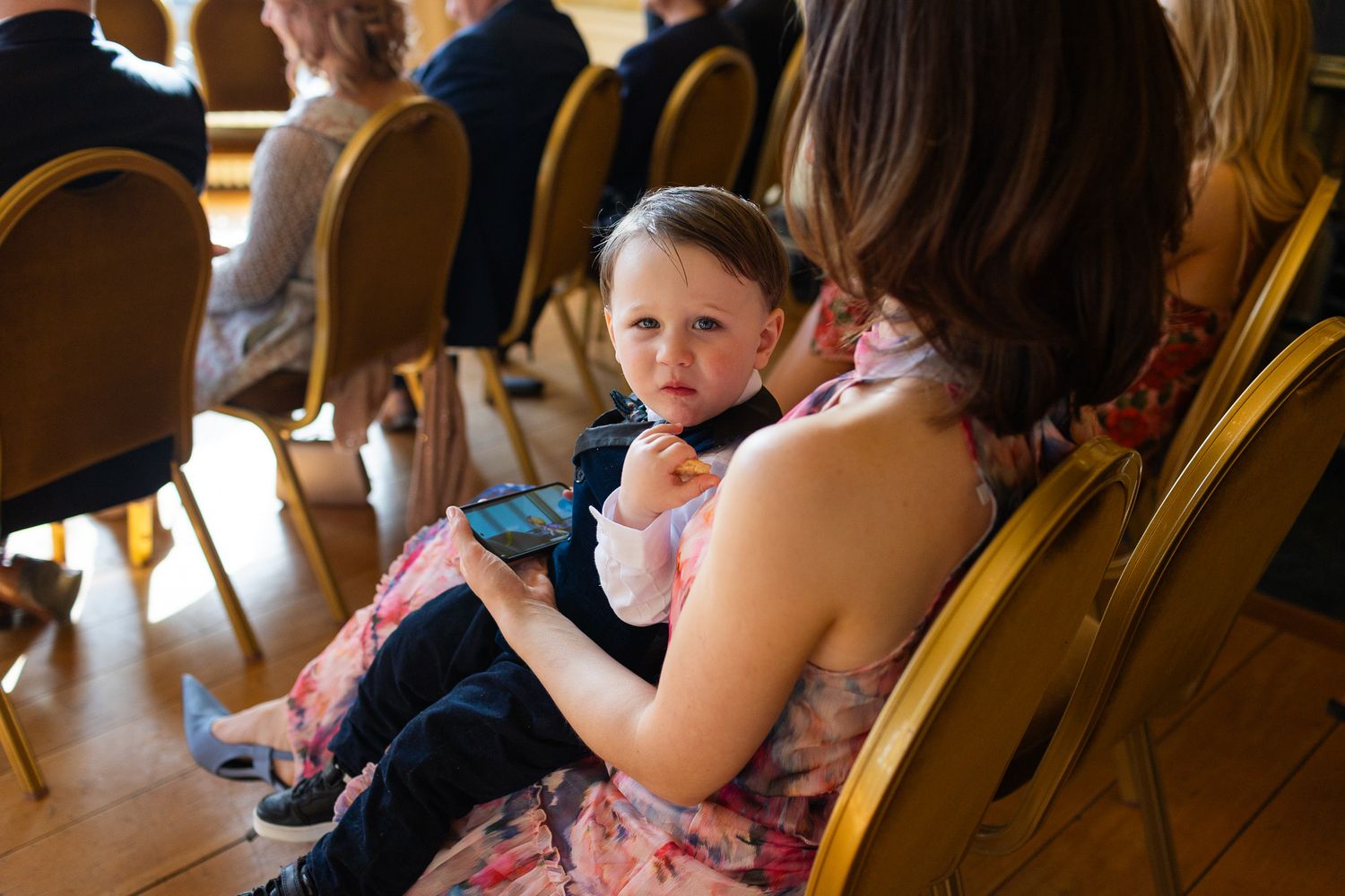 Wedding guests seated in gold chairs during an indoor ceremony at MoLI Dublin City.