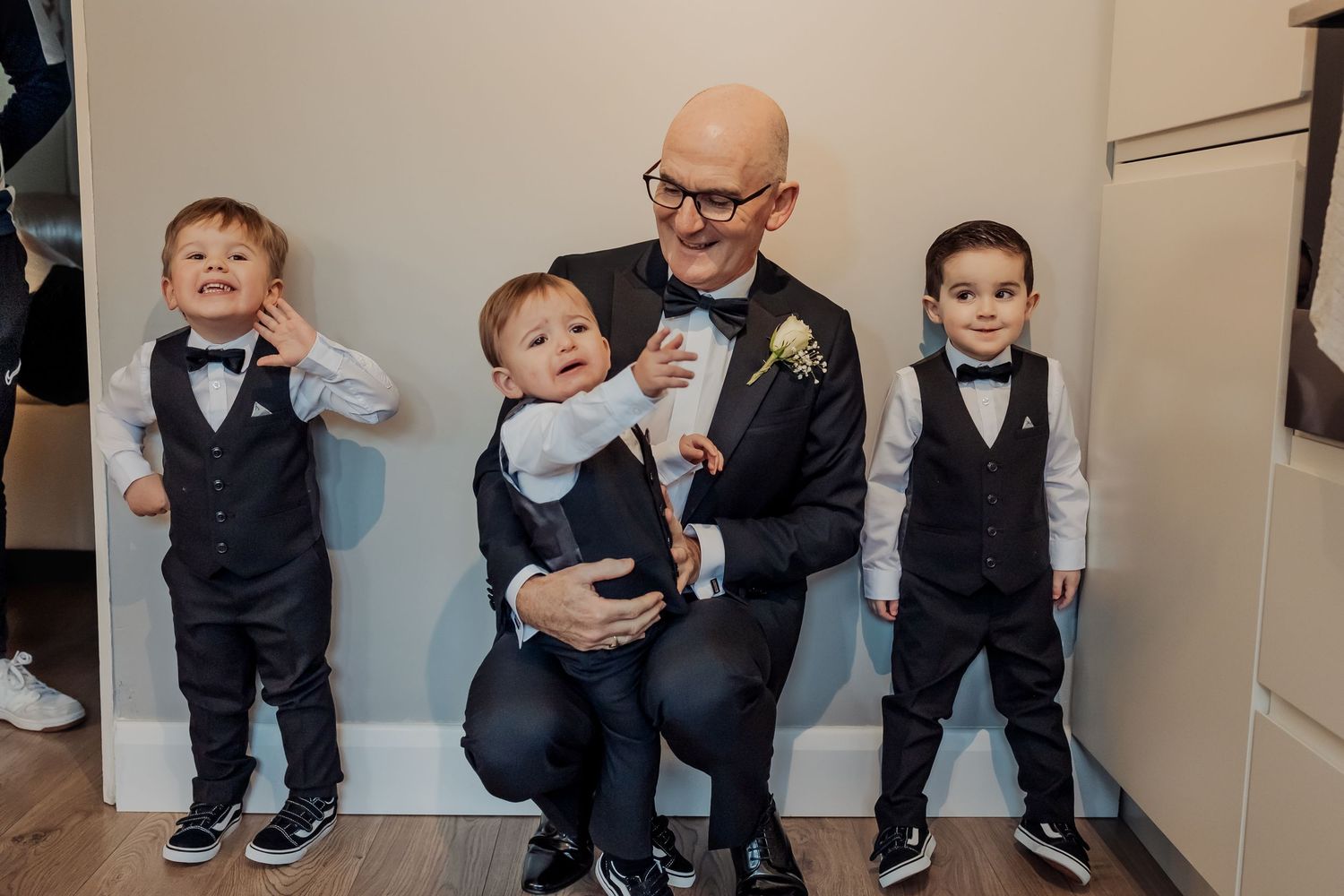 Group photo showing formal attire and casual poses against a neutral wall.