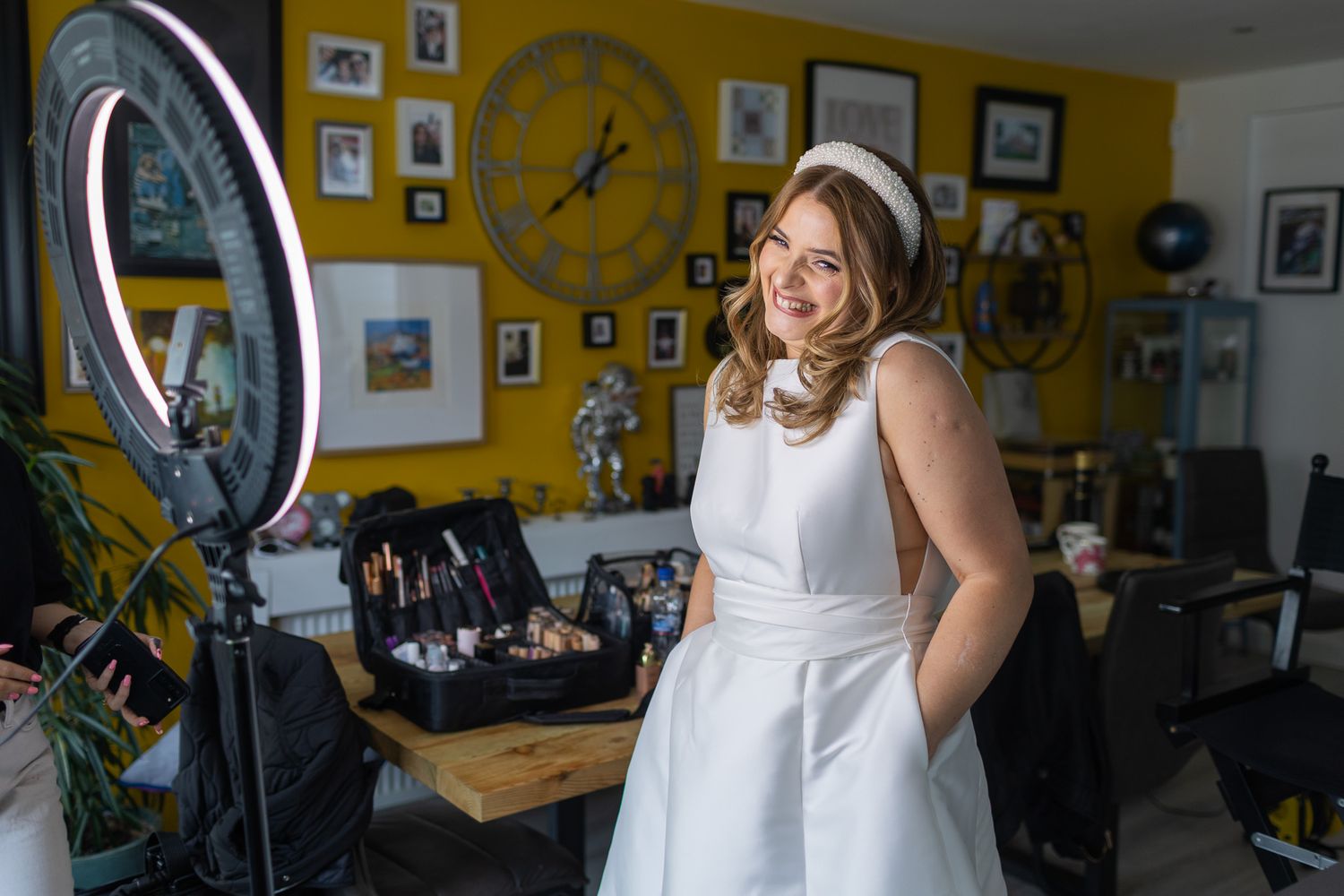 Photography shoot taking place in stylish room with yellow walls and framed artwork.