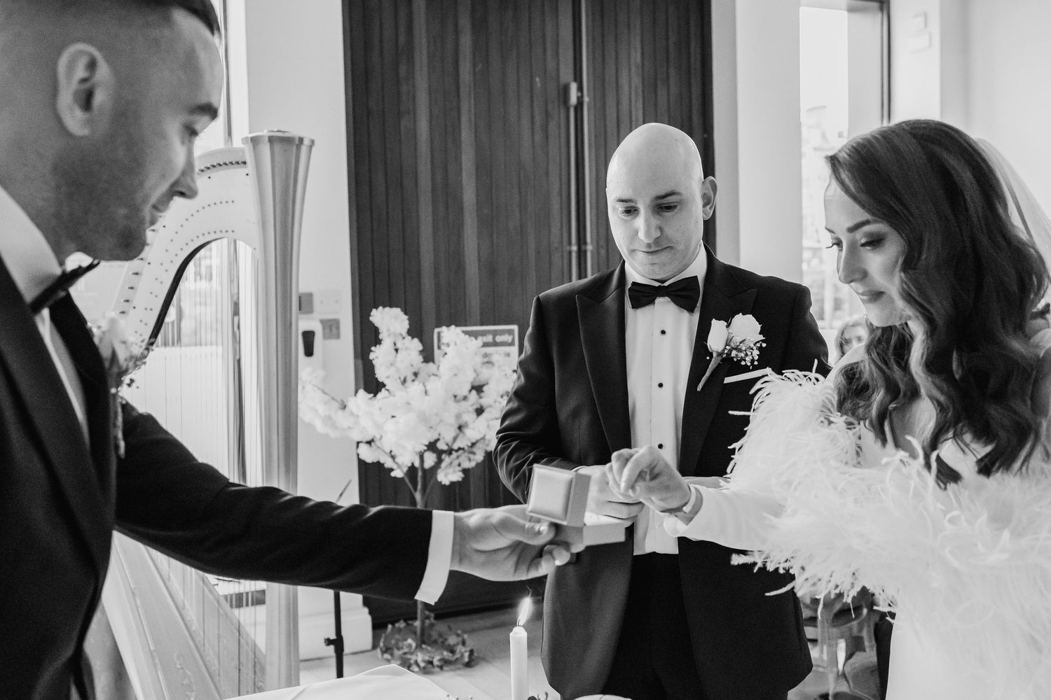 Wedding party members share intimate moments during an indoor reception celebration.