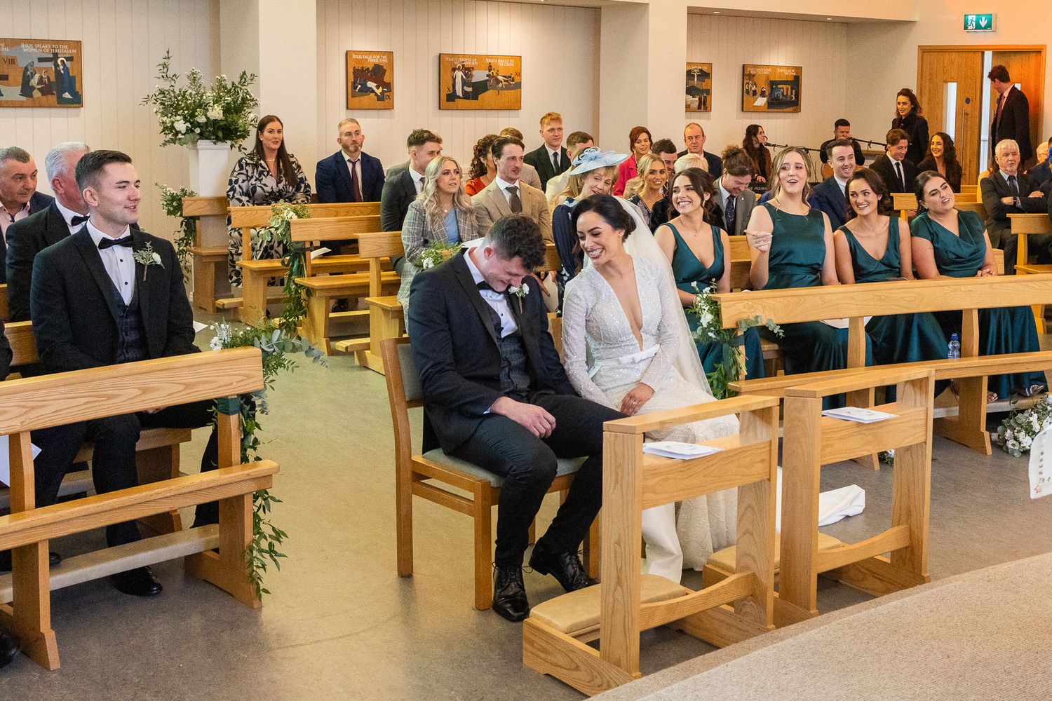 Wide view of a wedding ceremony space with guests seated on wooden pews during a Dublin city wedding.