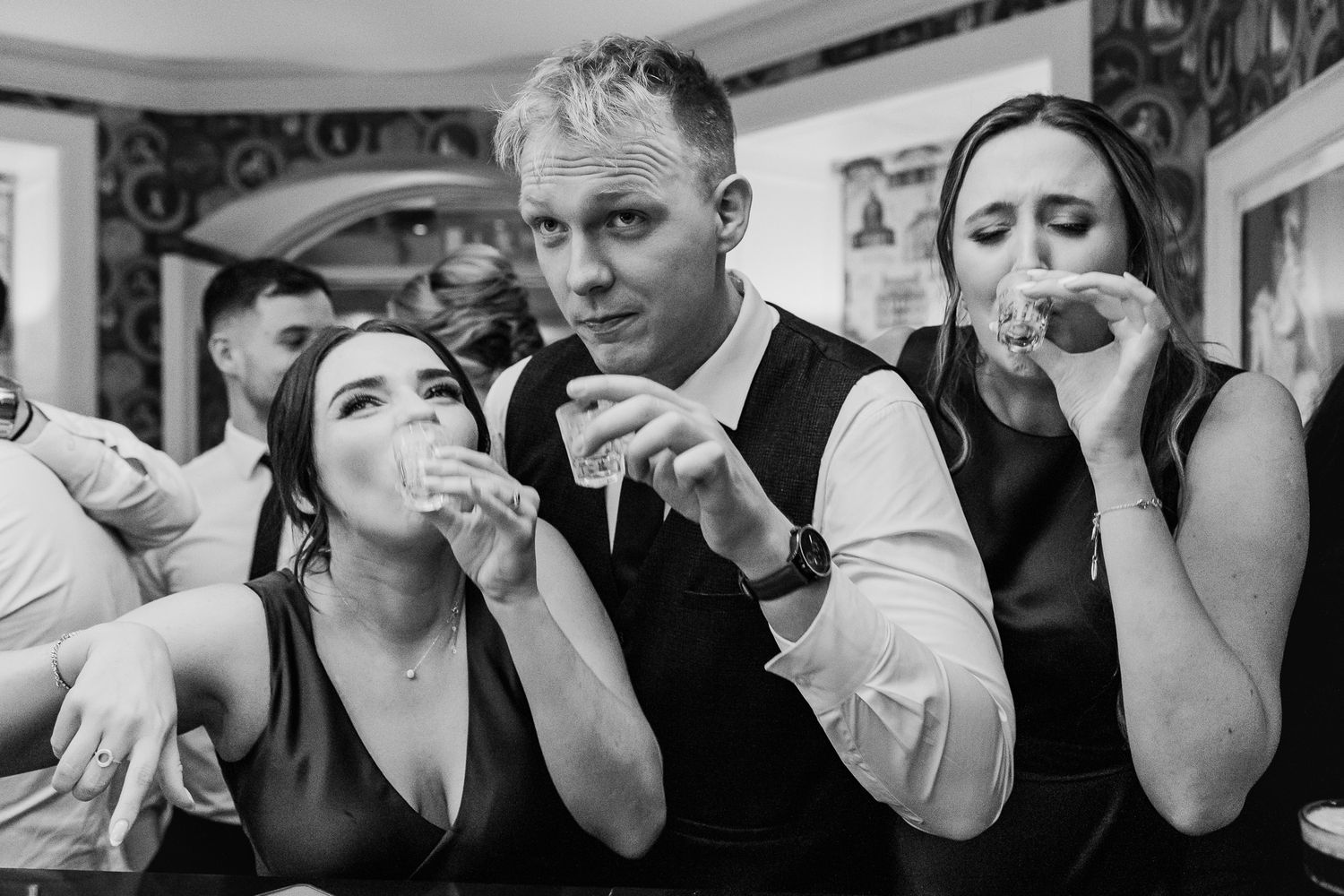 A group takes shots together at a Dublin wedding party celebration.