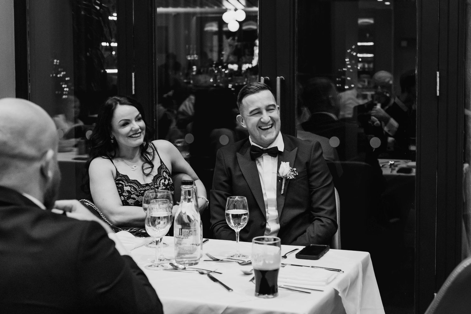 Wedding guests enjoying conversation and drinks at elegant reception tables.