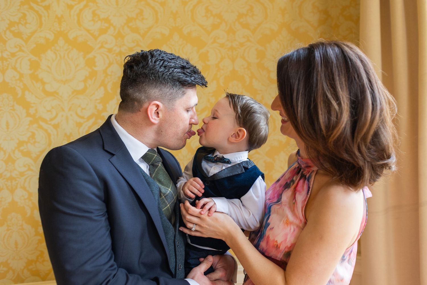 Intimate Dublin wedding photography moments captured in room with yellow damask wallpaper during celebration at the MoLI Dublin City Centre.