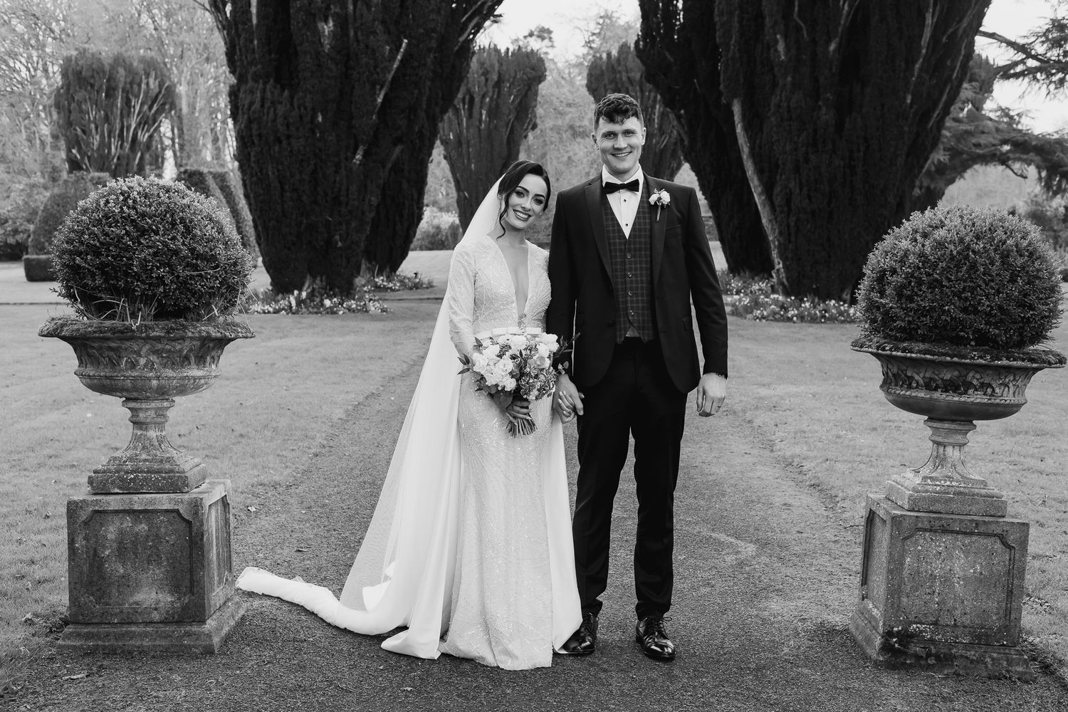 A natural wedding photos taken in front of ornate stone pillars in Tankardstown