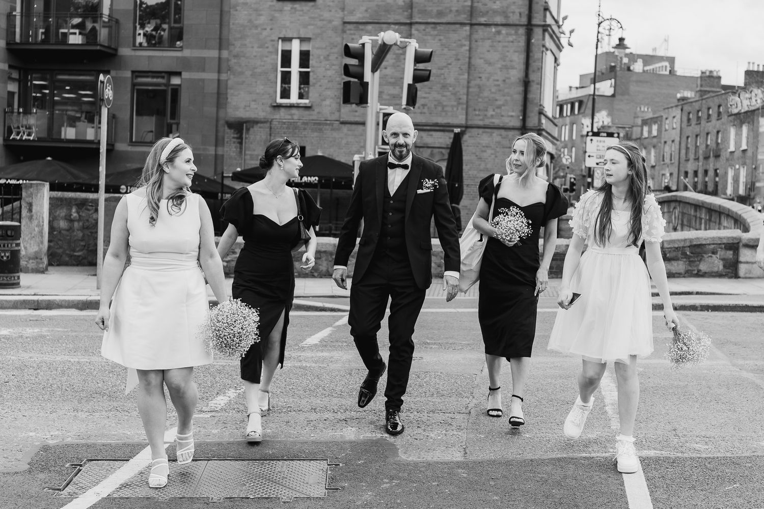 Wedding party walking through Dublin city streets wearing formal attire during a city wedding.