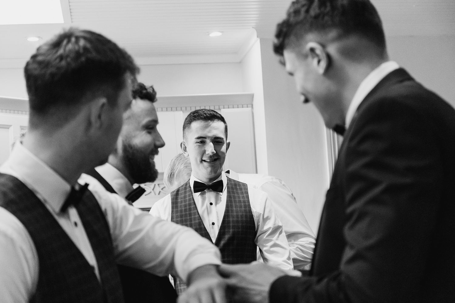 Black and white image of groomsmen getting ready in formal attire during Dublin Castle wedding.