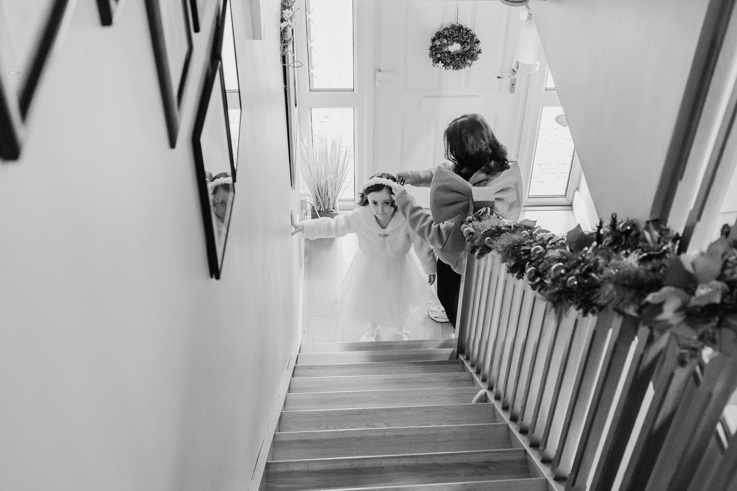 Black and white photos of a wedding party getting ready in a bright hallway.
