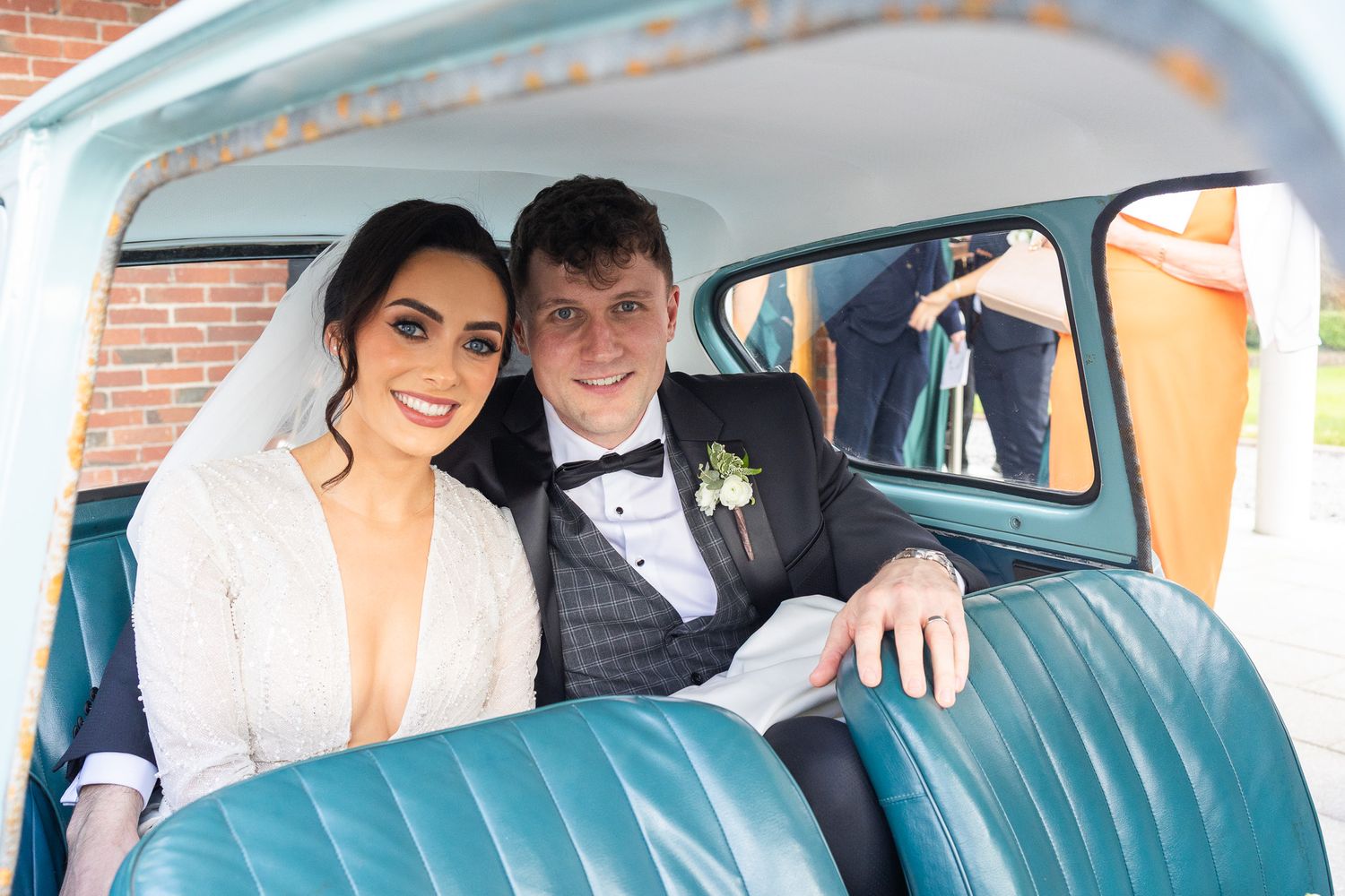 Classic vintage blue car decorated for a wedding with floral arrangements.