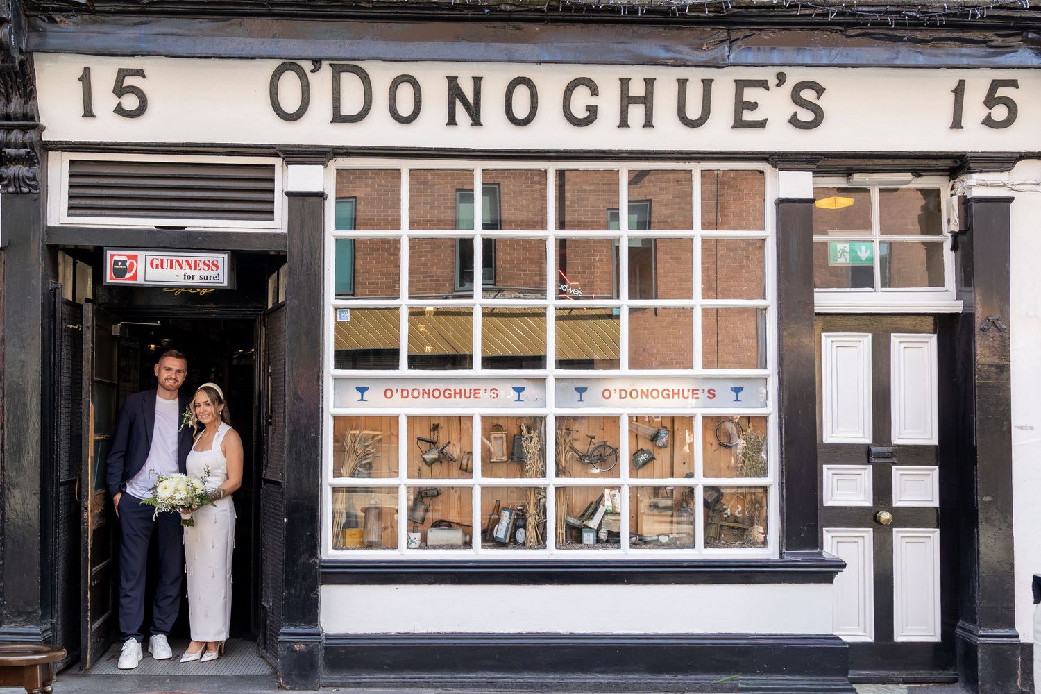 A bride and groom pose together outside O'Donoghue's pub number 15 on their wedding day.