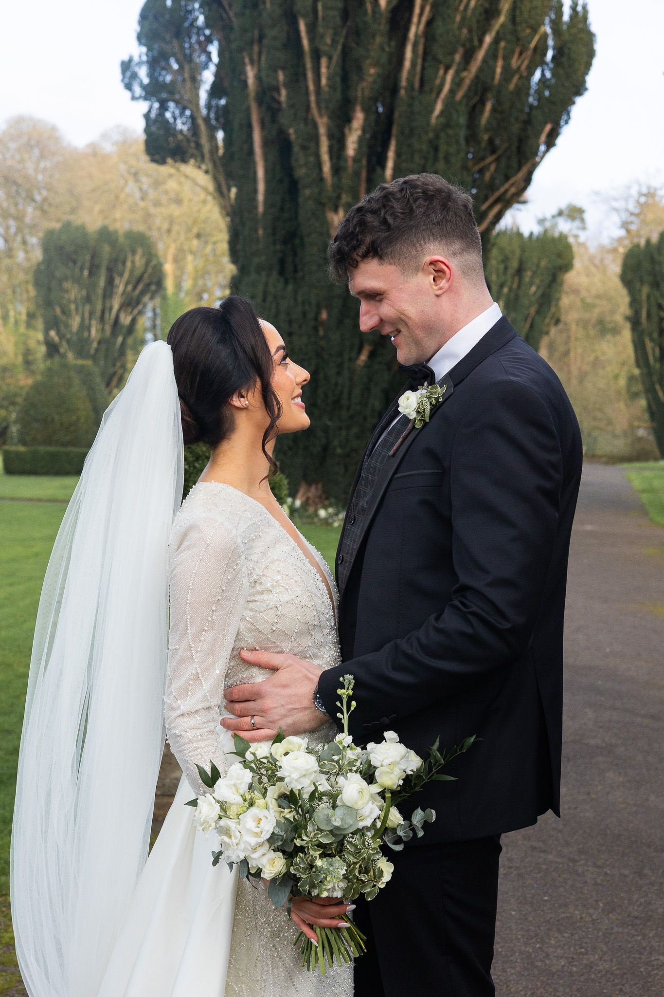 Romantic wedding couple embracing on a tree-lined by 25 Fitzwilliam Place wedding photographer